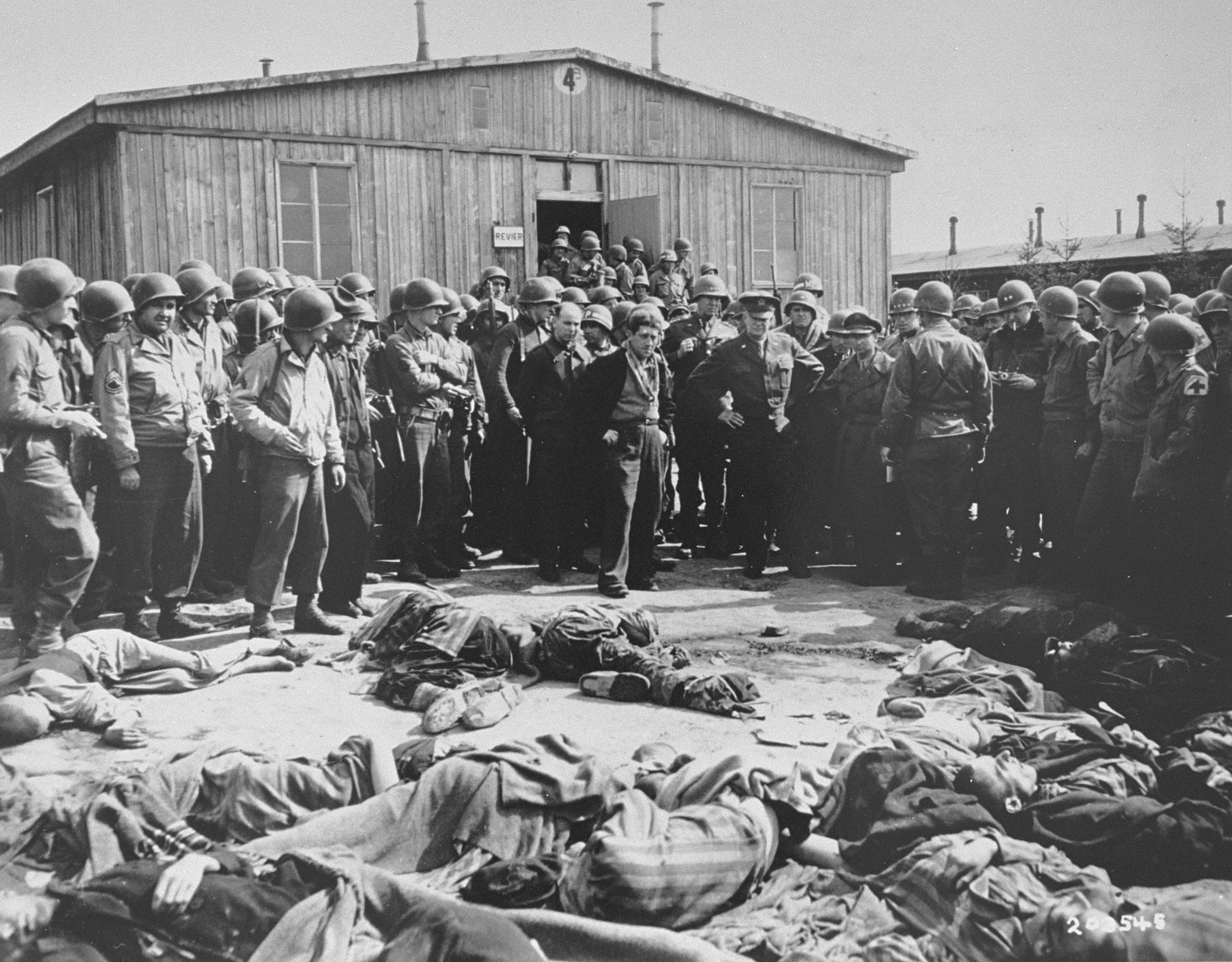 General Dwight Eisenhower and other high ranking U.S. Army officers view the bodies of prisoners who were killed during the evacuation of Ohrdruf, while on a tour of the newly liberated concentration camp.

Among those pictured is Ignaz Feldmann (wearing a dark coat and scarf, to the left of General Eisenhower) . He was a survivor of  Westerbork, Terezin, Auschwitz, and Ohrdruf camps.   He was also a player on the famed Hakoah Vienna soccer teams of the 1920s and 30s.