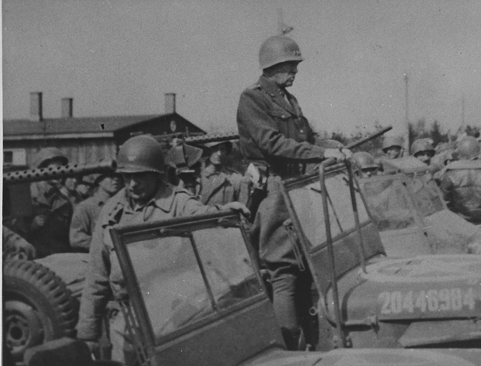 General George Patton (standing in the jeep) prepares to depart from Ohrdruf after an official tour of the newly liberated camp.