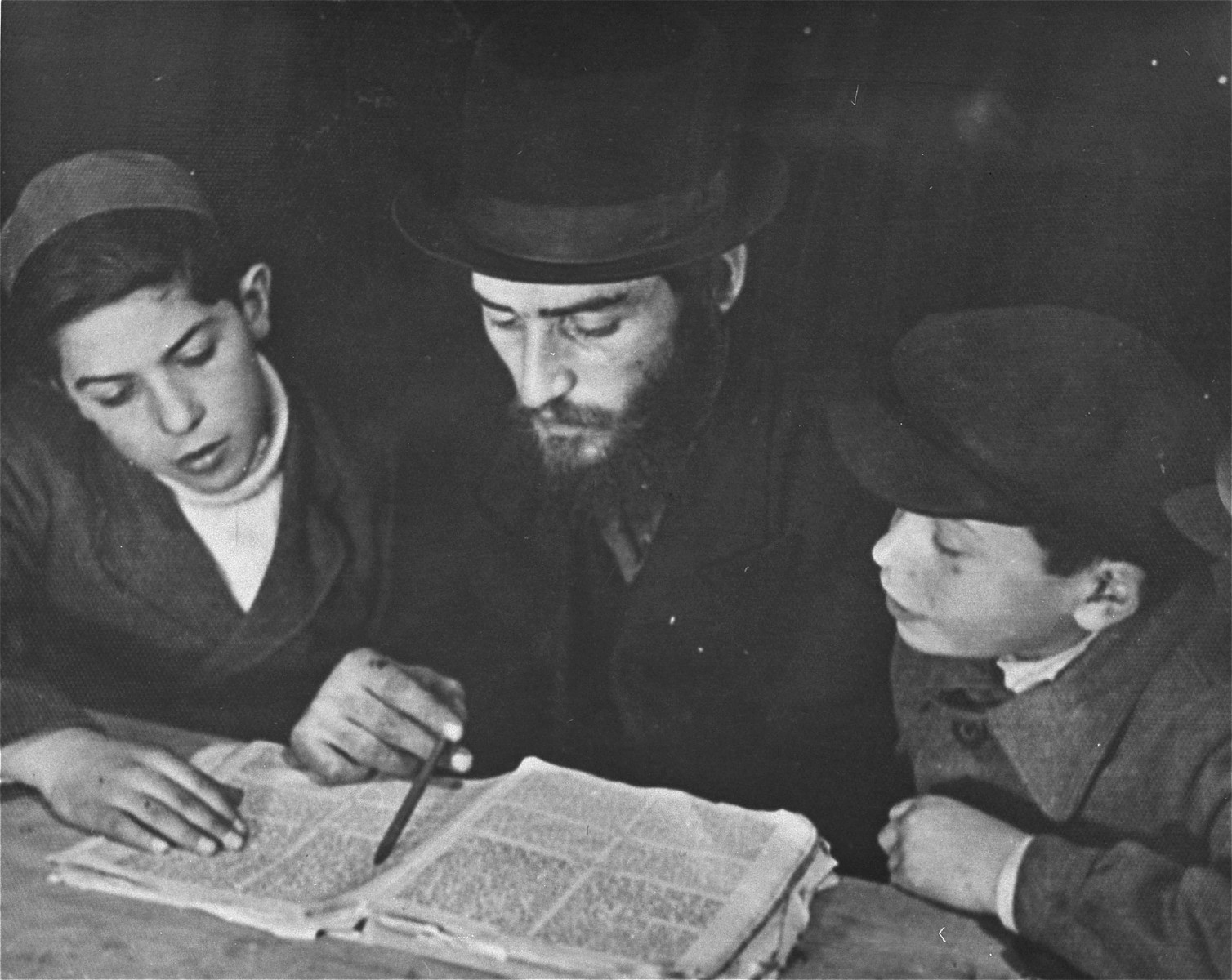 A Jewish DP studies Talmud with two children at the Landsberg displaced persons camp.