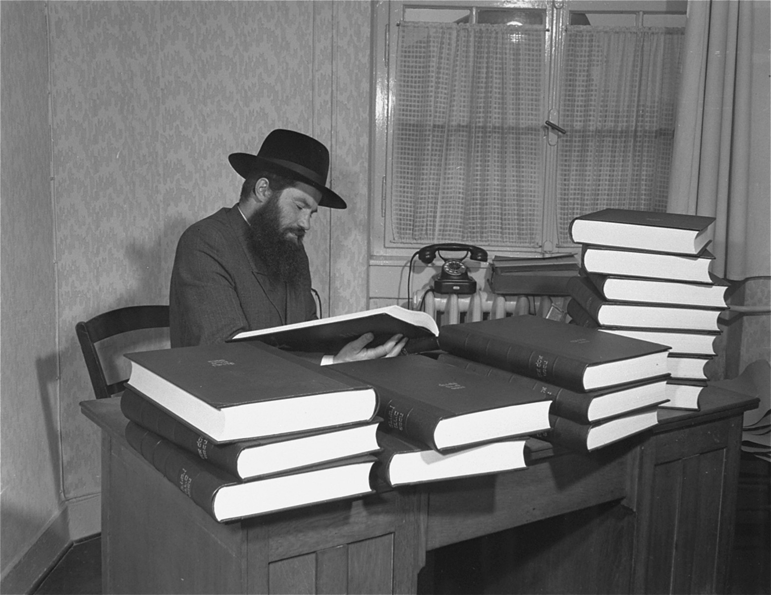 Rabbi Samuel Jakob Rose, Rabbi of the American zone of occupation in Germany, and a survivor of Dachau, examines one of the newly printed volumes of the Talmud.  

This is the first edition of the Talmud to be printed in Germany since Kristallnacht.