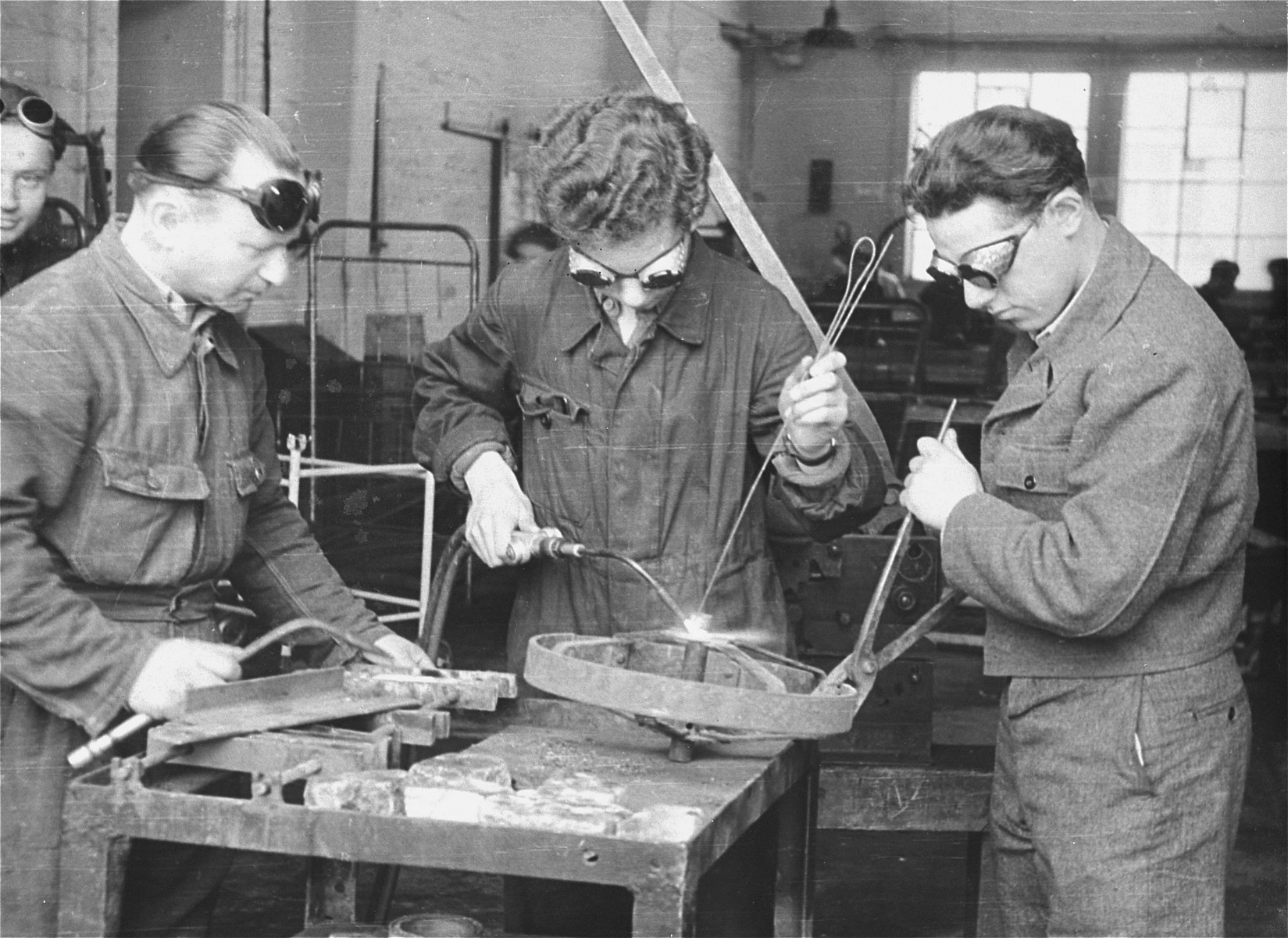 Three men practice welding in an ORT (Organization for Rehabilitation through Training) vocational training program in the Landsberg displaced persons' camp. [Oversized print]