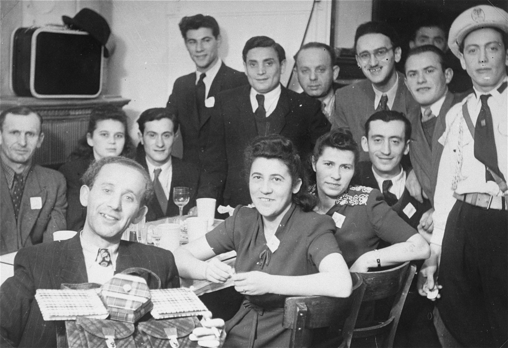 Group portrait of Jewish DPs gathered around a table in the Mittenwald displaced persons camp.