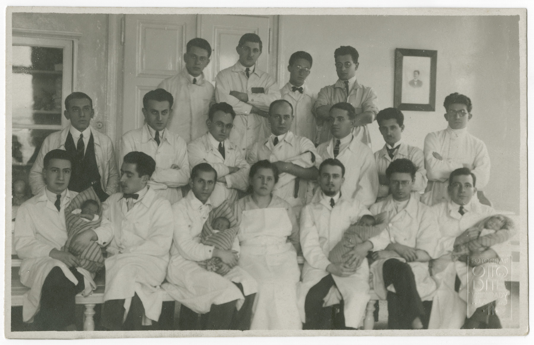 Group portrait of the Department of Obstetrics and Gynecology at Charles University in Prague.  Some of the physicians are holding recently delivered babies.

Dr. Kurt Grunwald is seated on the bottom left.