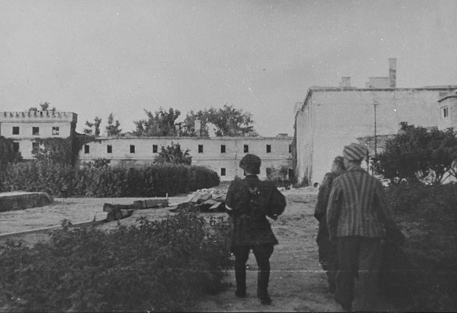 A member of the Zoska battalion of the Armia Krajowa escorts two of 348 Jews liberated from the Gesiowka concentration camp by the battalion, during the 1944 Warsaw Uprising.