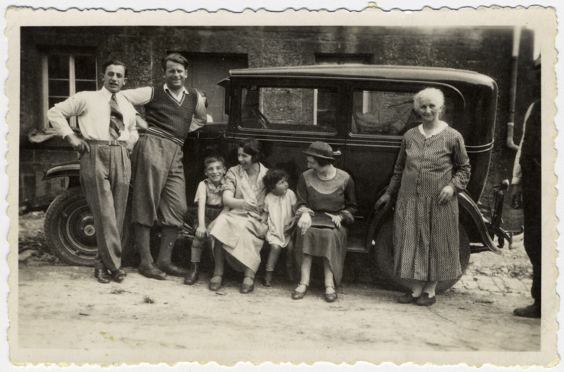 The Kalberman family poses next to an automobile.

From left to right are Leo and Manfred Kalberman, Max Kalberman, his mother Recha, Margot Kalberman, her mother Mella and Grandmother Rosa Kalberman.