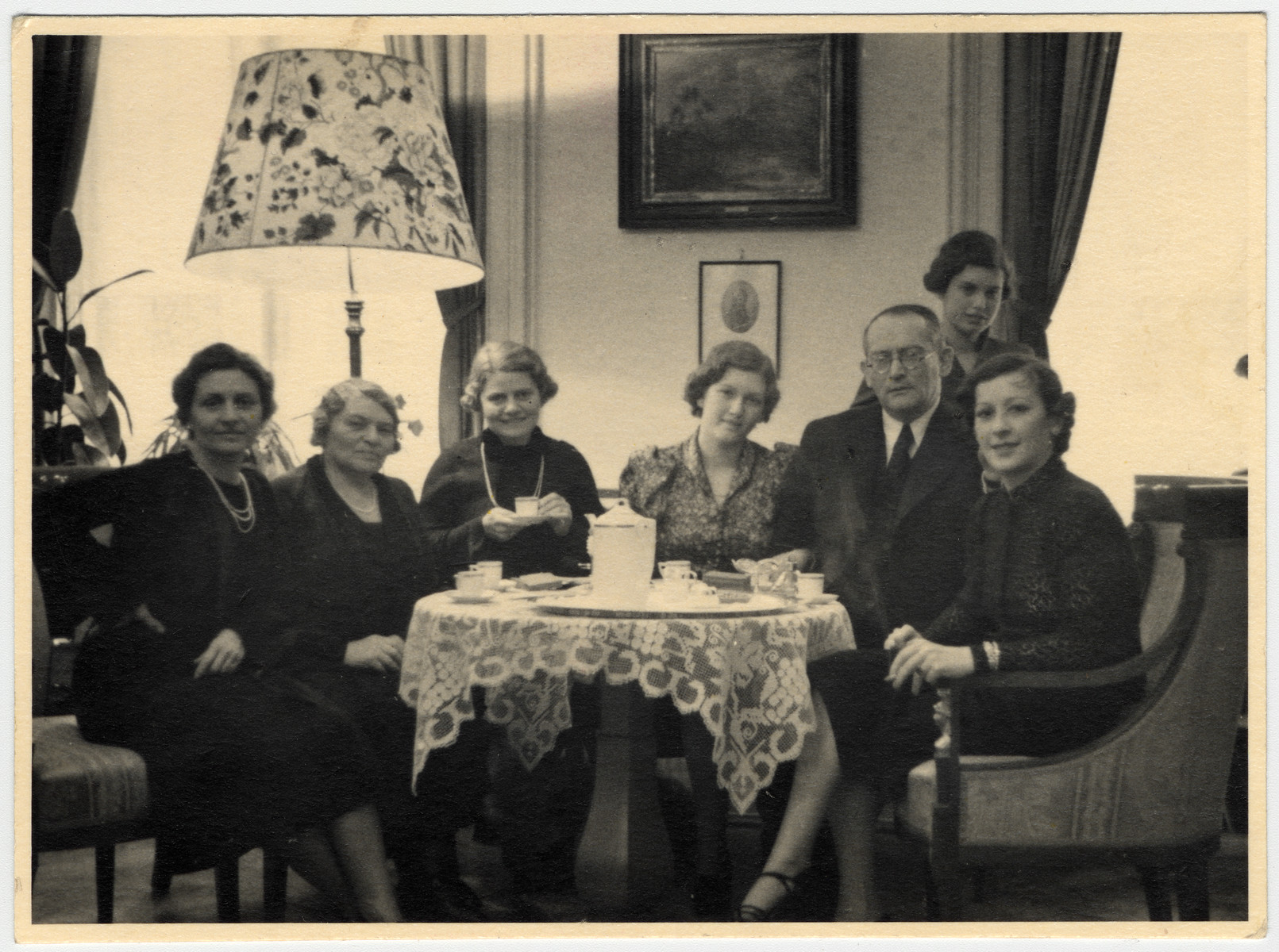 A Jewish family in Czechoslovakia poses by a table laden with coffee cups on the wedding day of their daughter, Lotte Aldor (the cousin of the donor).

Pictured from left to right are Marianne Aldor (the mother of the bride), Gusti Aldor, Emmy Aldor (sister of Marianne), Lotte Aldor, Robert Ayer, Mimi (Lotte's sister) and unidentified.