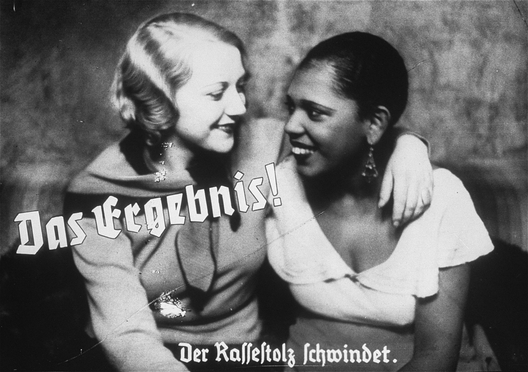 Propaganda slide depicting friendship between an Aryan woman and a Black woman as a loss of racial pride.  The caption reads, "The result/Racial pride fades."