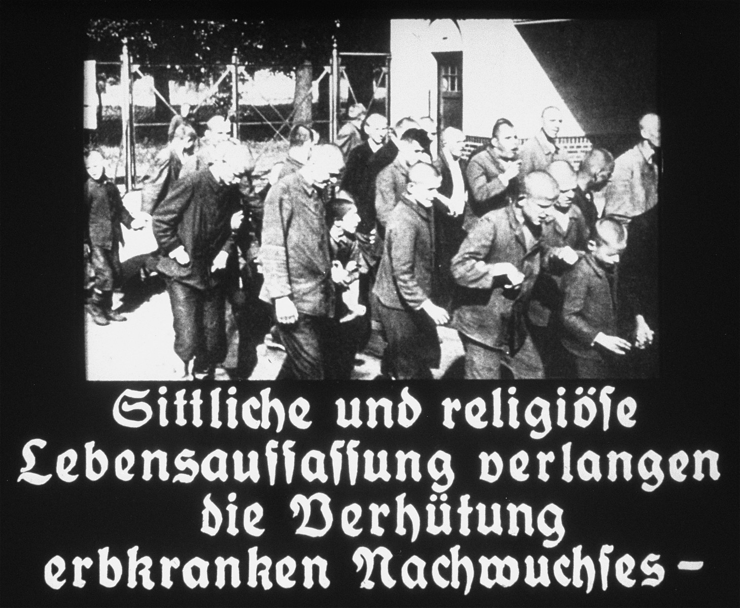 Propaganda slide featuring a a group of mentally ill patients being escorted outside in an unidentified asylum.  The caption reads, "Moral and religious concepts of life demand the protection of the congenitally ill."