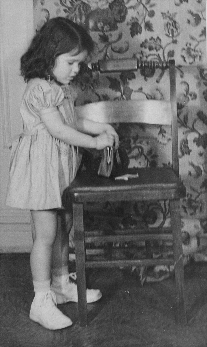 Portrait of the donor, Haviva Kaplan, as a young girl playing with a purse in her home in New York.