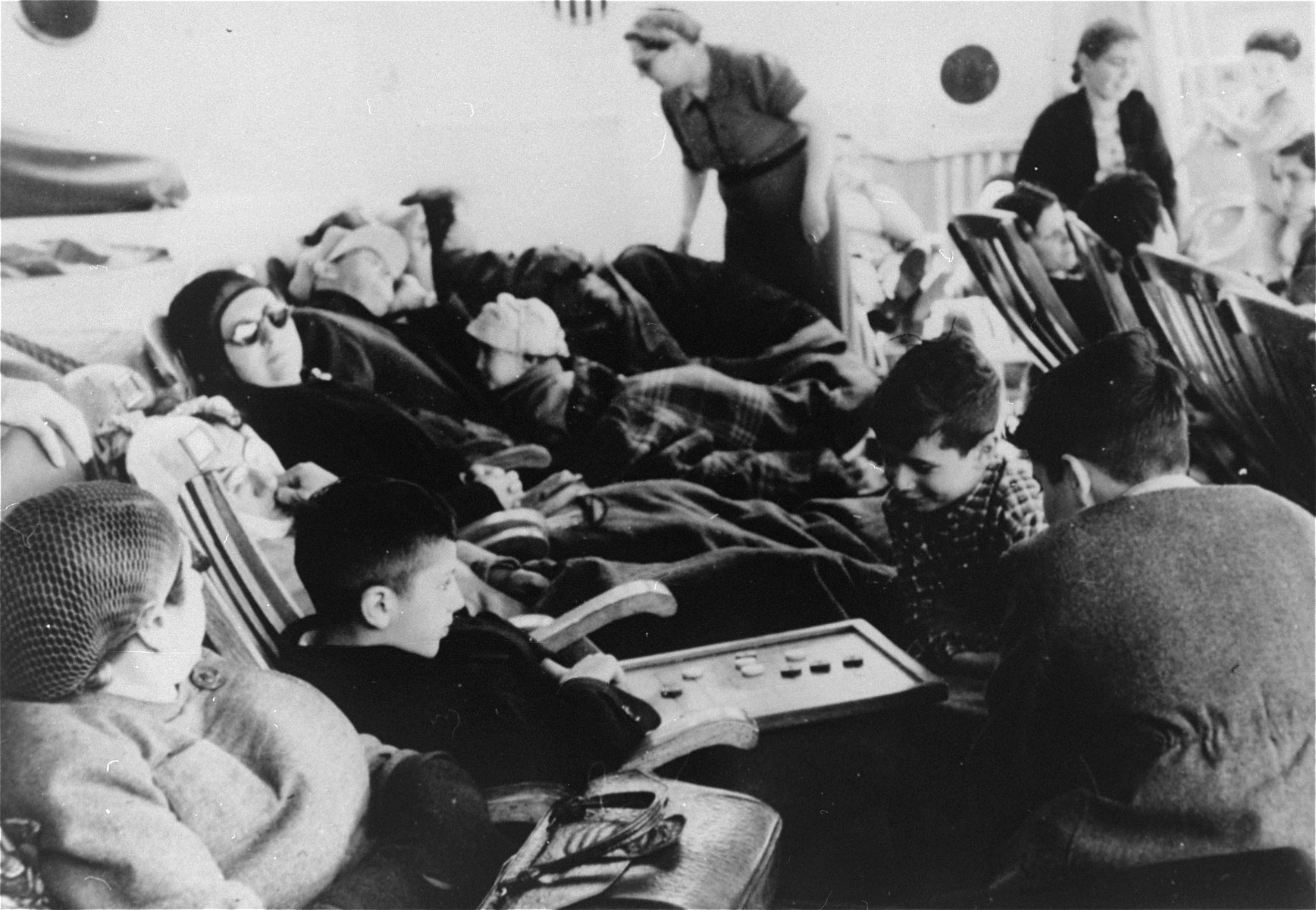 German Jewish refugees relax on the deck of the SS Iberia during the voyage from Lisbon to Havana.  

Among those pictured are Manfred and Klaus Gallewski.
