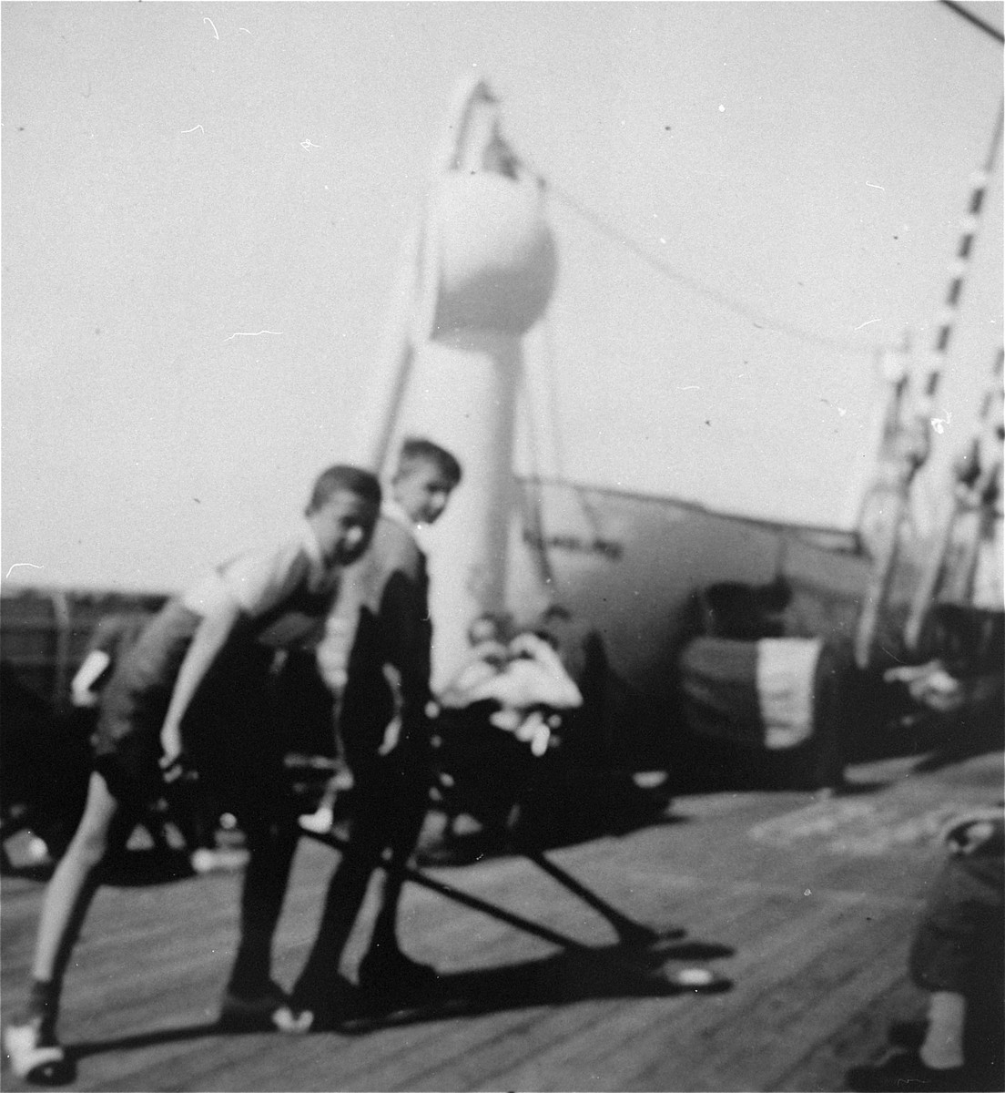 Two German Jewish refugee youth play shuffleboard on the deck of the SS Iberia during the voyage from Lisbon to Havana.  

Pictured are Peter Froehlich and his friend "Kolmke."