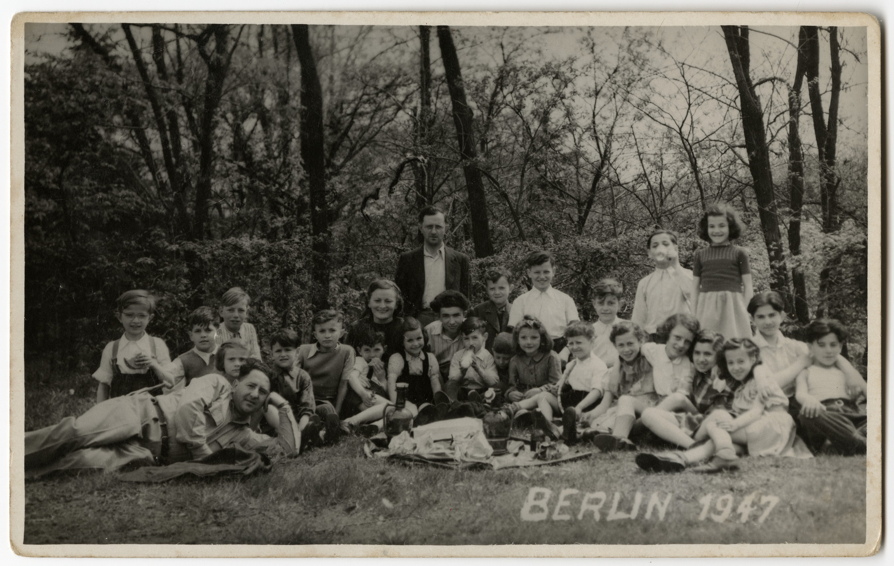 Group portrait of children and teachers from the Schlachtensee displaced persons camp.

Among those pictured is Benny Rubinstein.