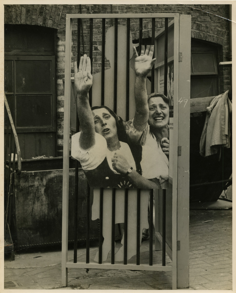 Panel from a 1944 exhibition in London, England, entitled "Germany- the Evidence" showing German women extending their right arm in the Hitler salute.  

Panel shows presumably German women zealously extending their right arm in the Hitler salute dressed in traditional dirndl skirts. 

The back of the photo reads "British Official Photograph; Distrbuted by the Ministry of Information. D. ; The Evil We Fight.; Ministry of Information Exhibition priduced by Display &Exhibitions Division for show all over Great Britain.; Display panel"