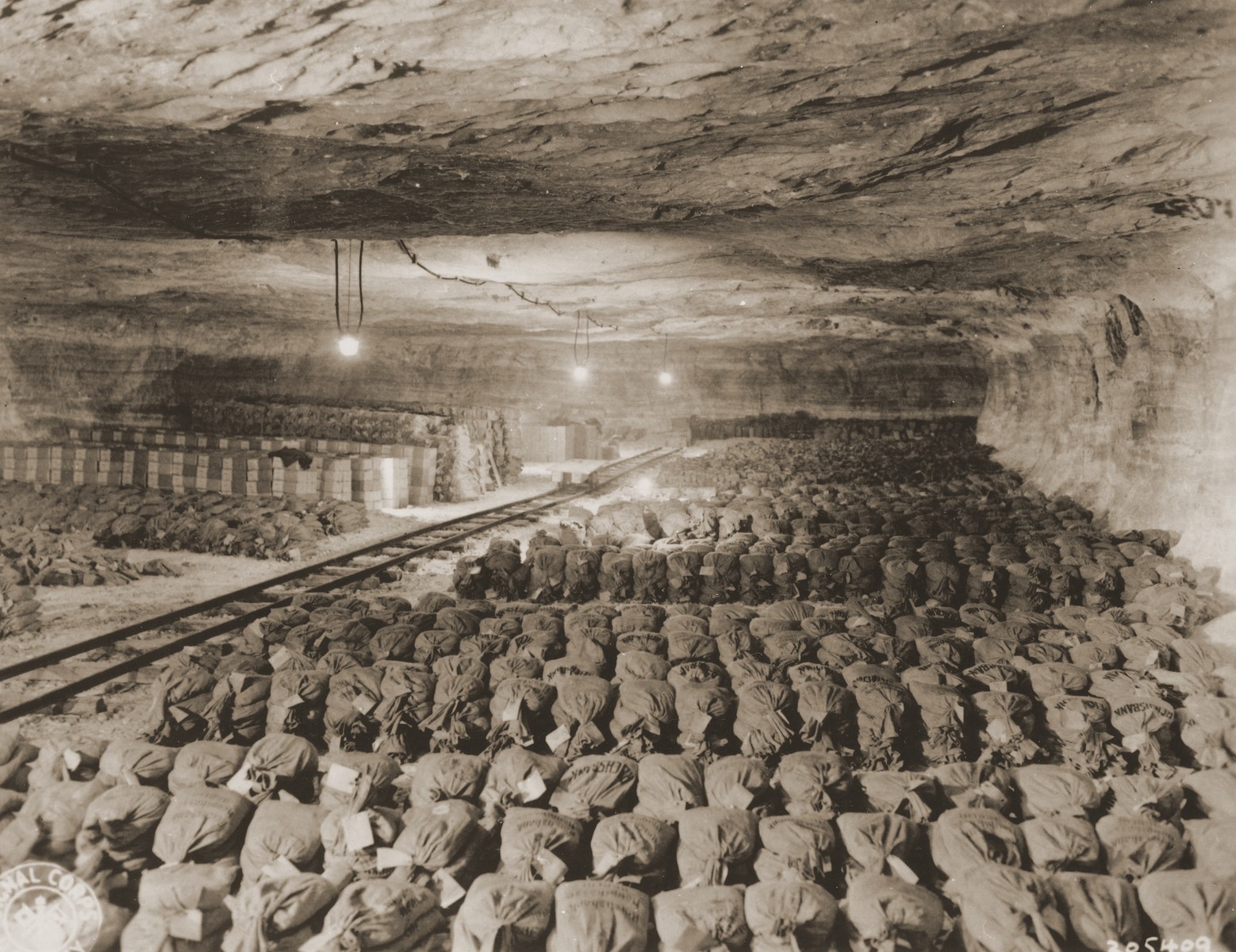 Bundles of currency, confiscated art, and other valuables from Berlin are uncovered by U.S. troops with the 90th Division, U.S. Third Army in the Merkers salt mine.