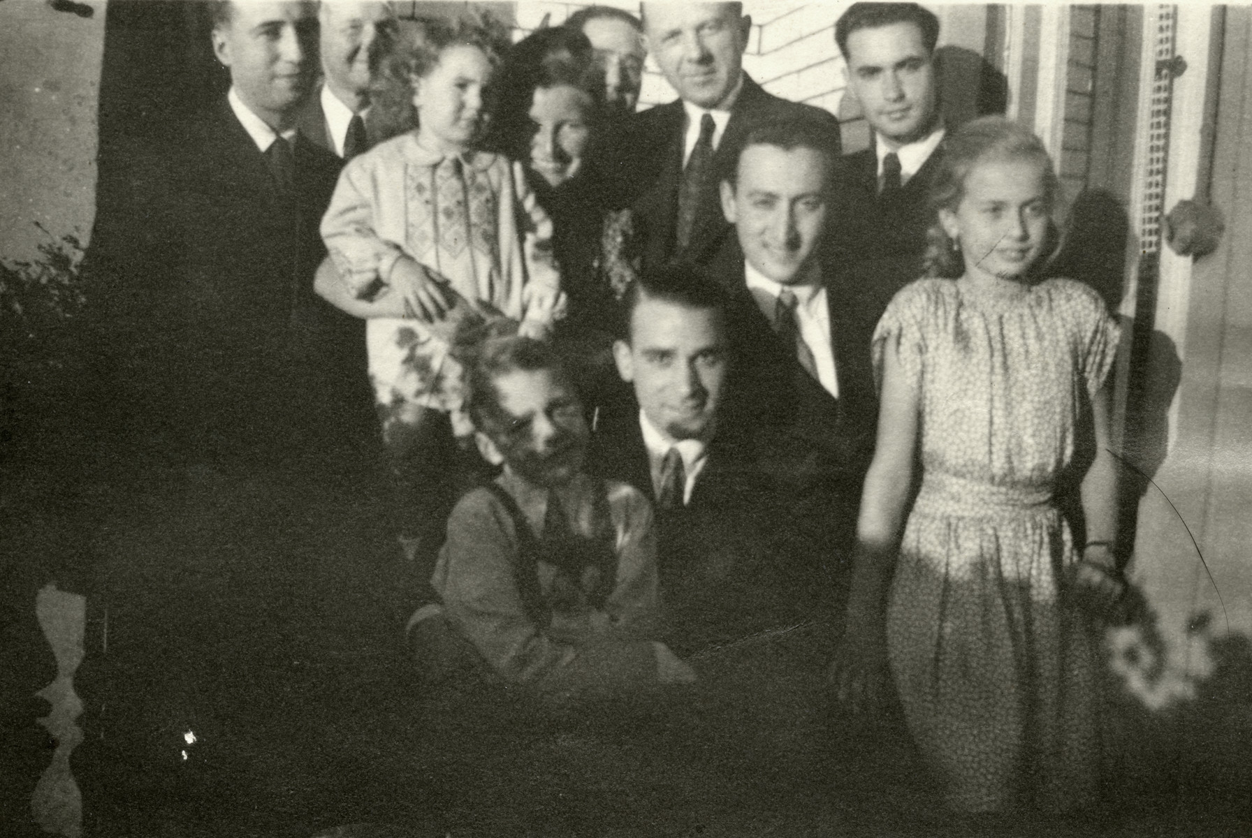 Mali Lamm, a Jew in hiding, poses with her rescuer's daughter and a group of men.

Mali Lam is pictured in back holding young child. Gerda Kreisse is pictured on the right.