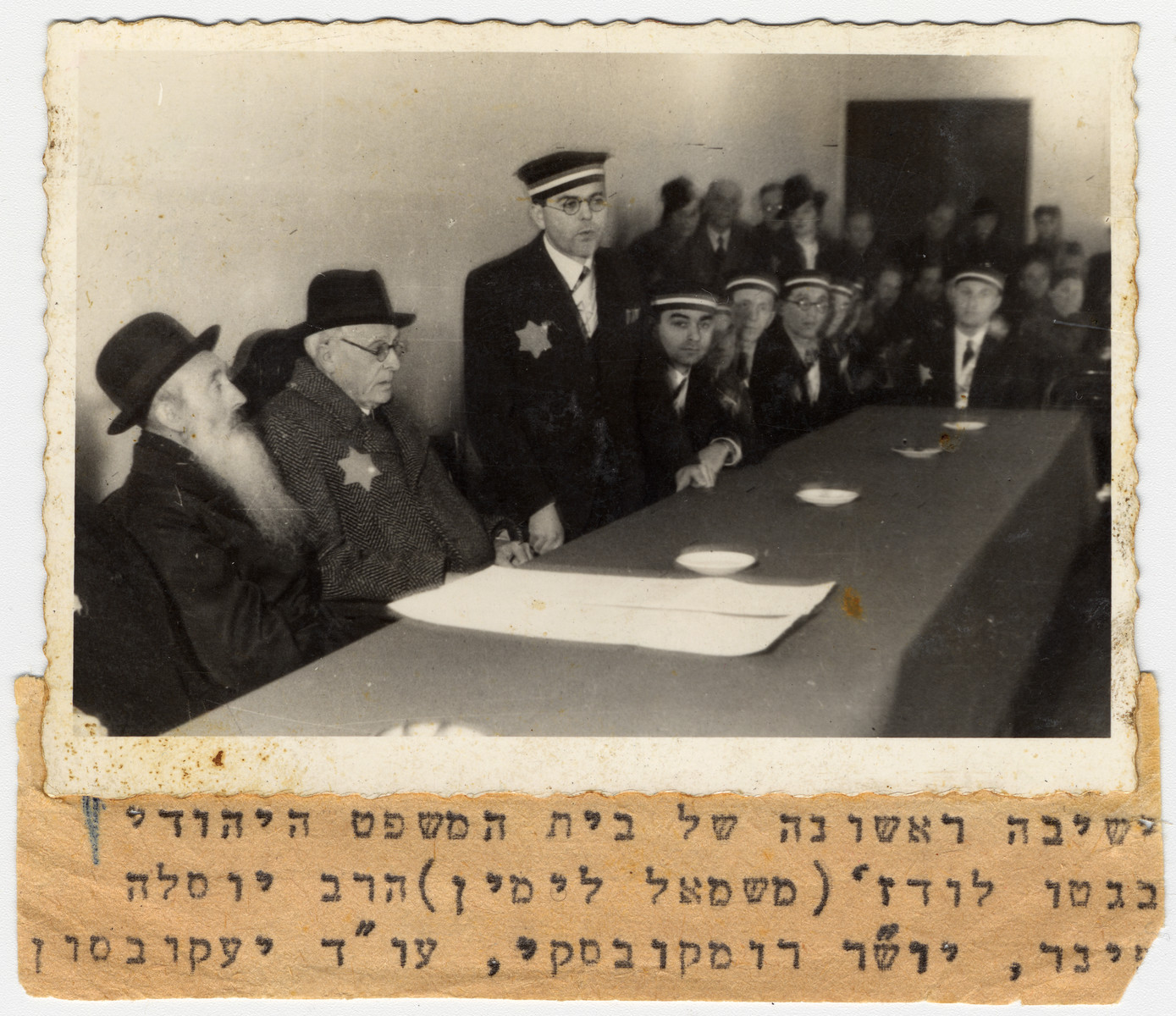 Mordechai Chaim Rumkowski, chairman of the Jewish Council in the Lodz ghetto, attends the swearing-in ceremony for the judges of the Jewish court.

Speaking is attorney Stanislaw Jakobson.  Pictured on the right of Rumkowski is Rabbi Yosif Fajner.