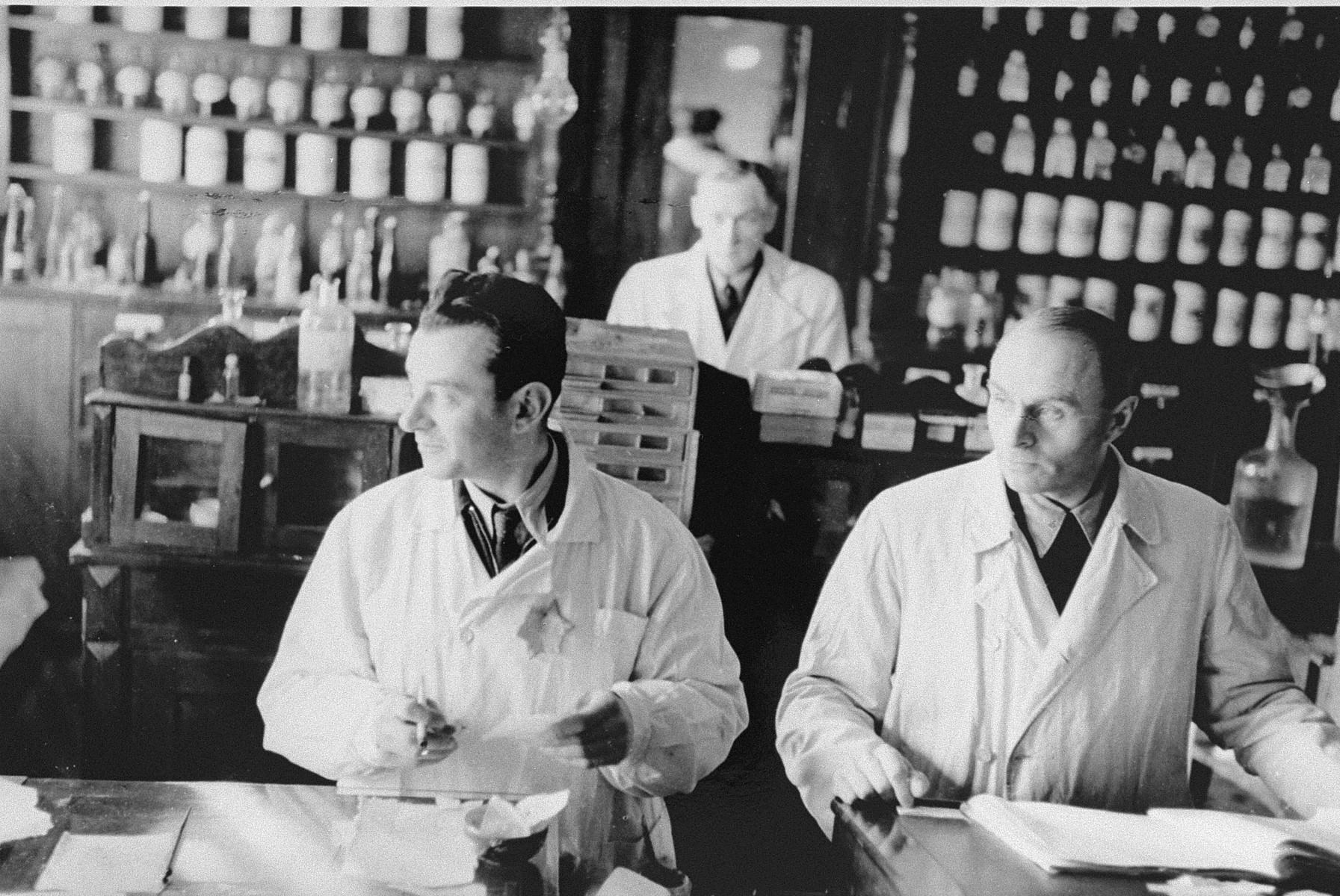Jewish pharmacists at work in the only pharmacy in the Kovno ghetto. 

Among those pictured are head pharmacist Aizik Srebnitzki (left), and N. Segalsohn (from Memel).

Aizik Srebnitzki, who was active in the ghetto's Zionist underground, kept a clandestine radio in the basement of the pharmacy for use by the underground.