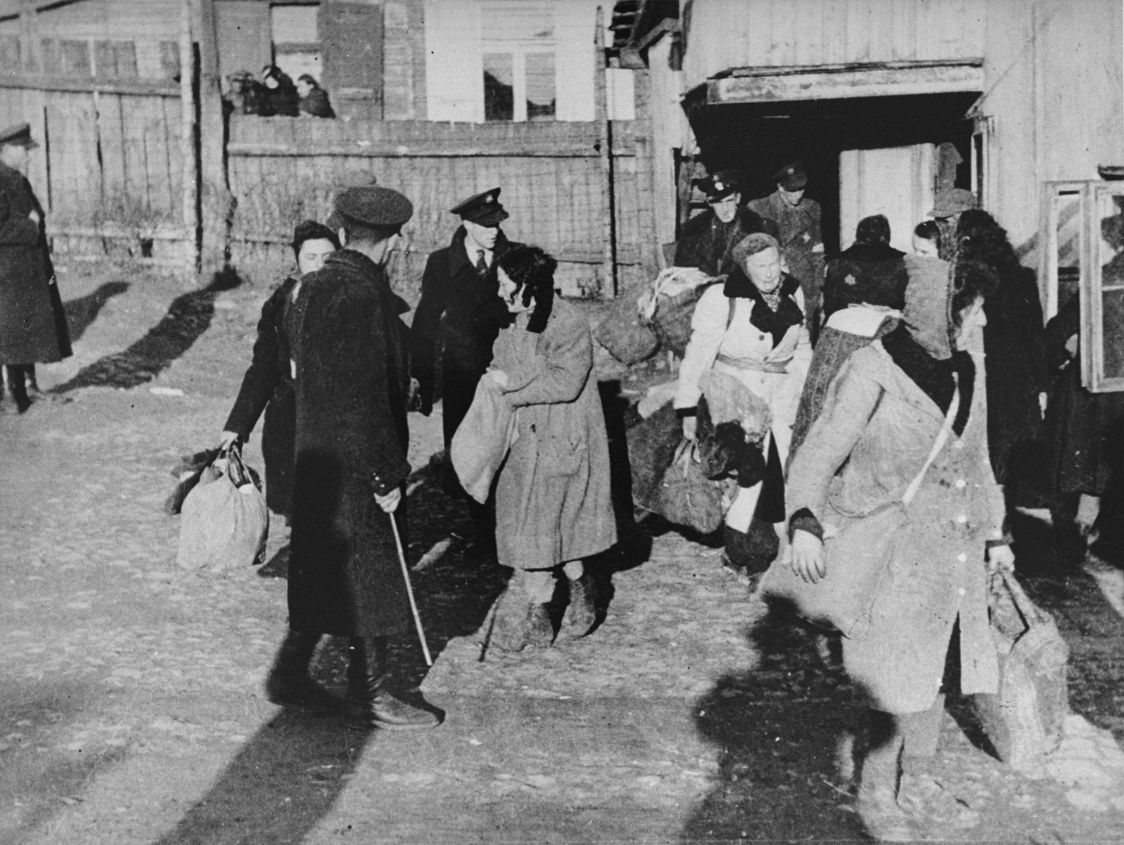 Jewish police direct people to the assembly area in the Kovno ghetto during a deportation action to Estonia.

Photographer George Kadish captioned the photo  "Transfer to nowhere".
