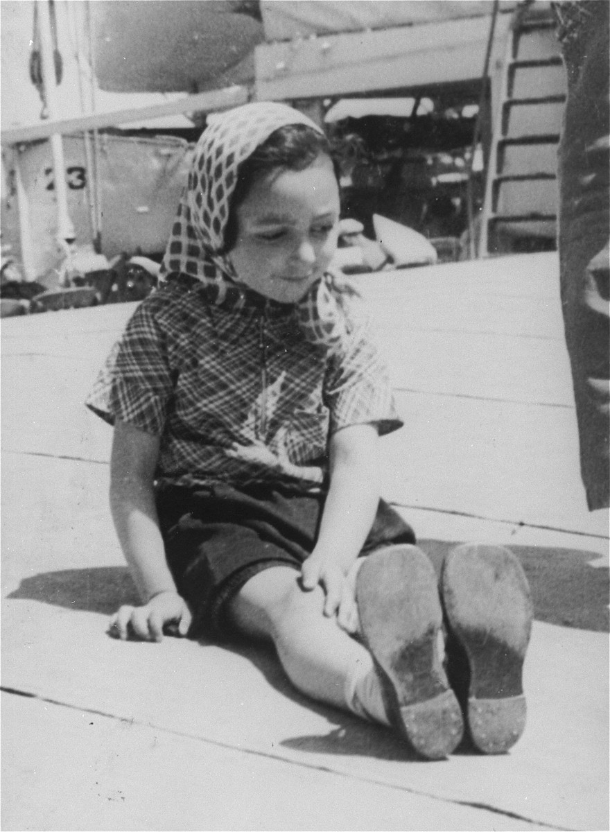 Photo of a young girl sitting on the deck from the personal St. Louis photo album assembled by Lotte Altschul.