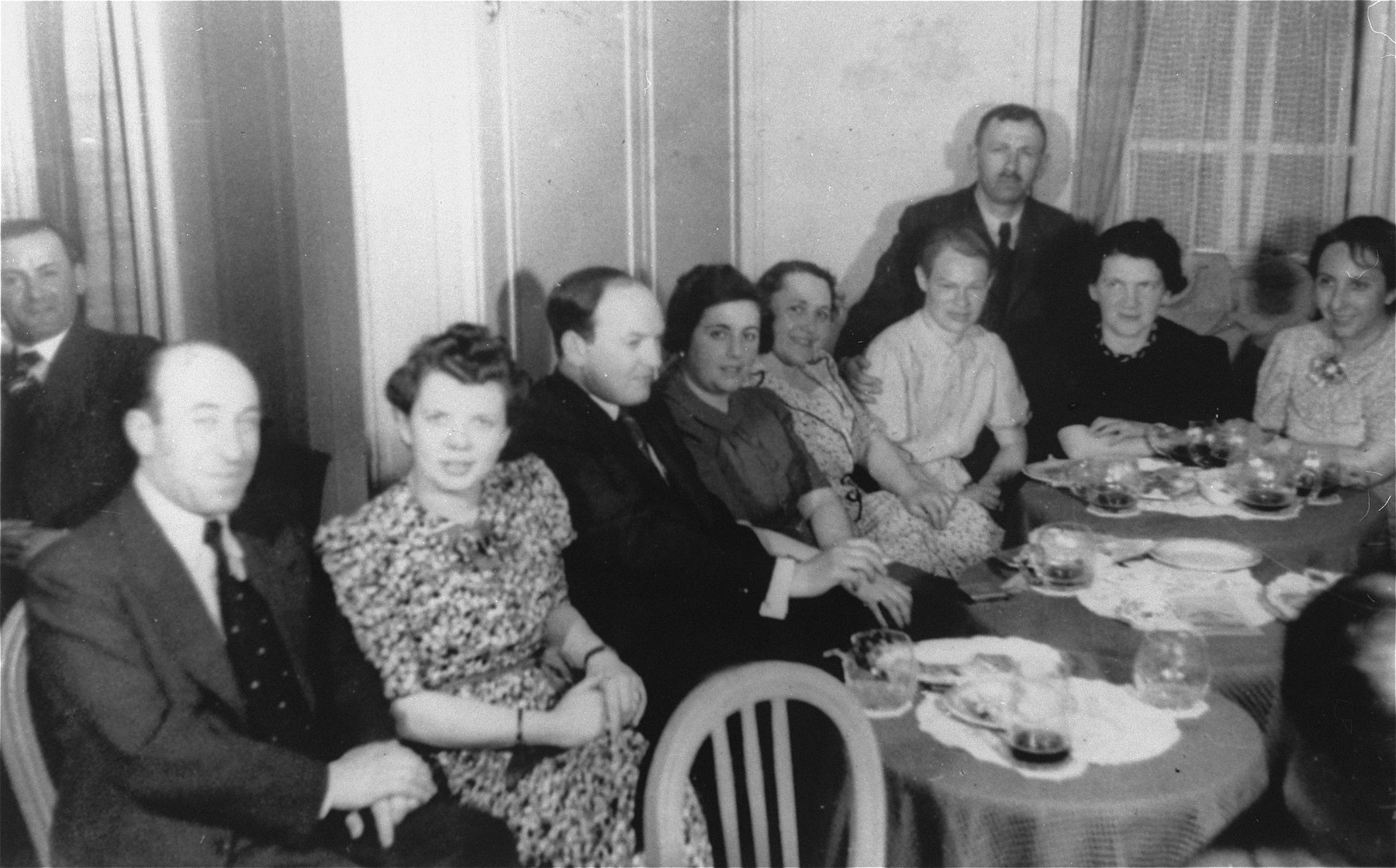 Passengers on board the MS St. Louis sit around tables in the dining area.  

Among those pictured are Joseph Karliner, Martha Karliner, Walter Weissler, Vera Spitz, Erna Ring, Gertrude Eskenazi and Grete Guttmann.