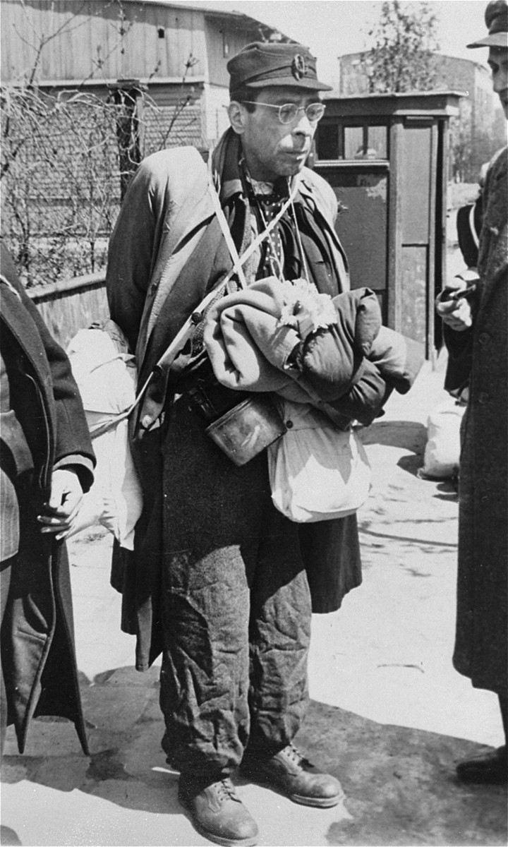 A German Jew, laden with his belongings, awaits at an assembly point for the deportation to the Chelmno death camp.  

On the right  is Dr. Josef Klementynowski, an employee of the Ghetto Archives.
 
Approximately 20,000 German, Austrian and Czech Jews were brought to the Lodz ghetto in the fall of 1941 and deported to the death camp in Chelmno in the spring of 1942.