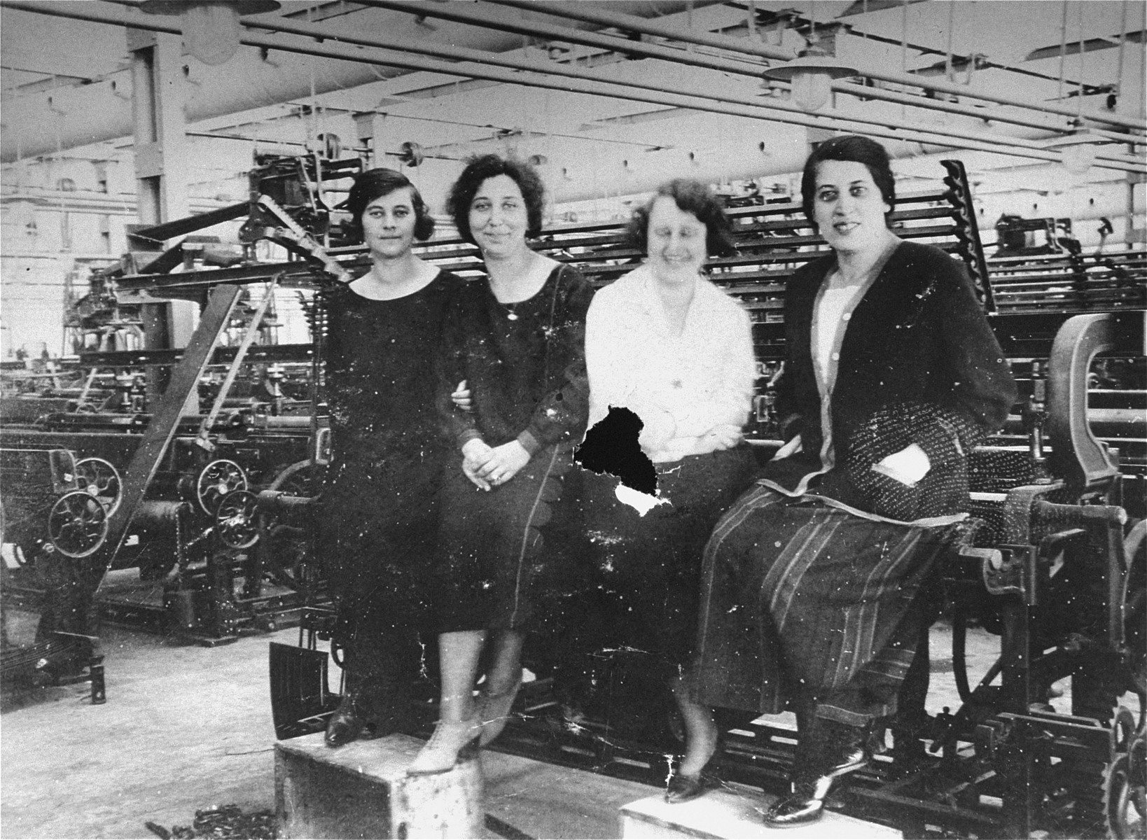 Four young Jewish female workers pose in the Goldberger textile factory in Budapest.  

Among those pictured is Margit Kornhauser (wearing the white blouse).