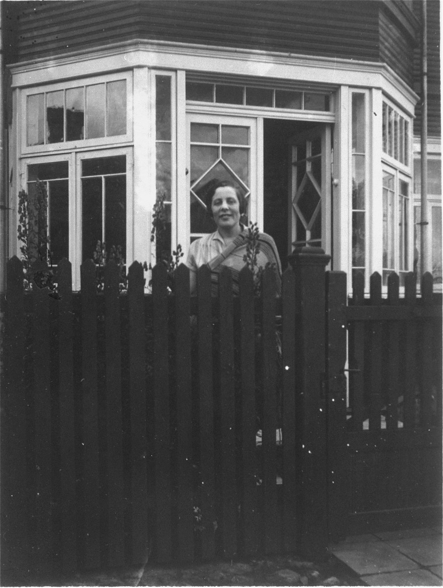 A young Jewish woman poses behind a fence in her front yard.

Pictured is Sonia (Lowenstein) Schereschevsky, the donor's great aunt, just before she left Siauliai to join her husband, Nathan, in South Africa.