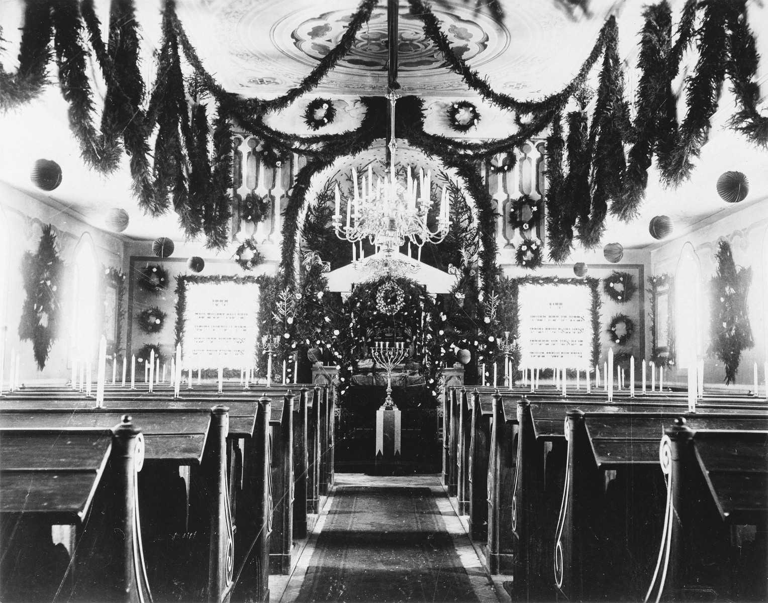 View of the sanctuary in the Buttenwiesen synagogue that is decorated with evergreens.

The synagogue in Buttenwiesen was not destroyed during Kristallnacht.  After the war it was converted into a school and later used for other purposes.
