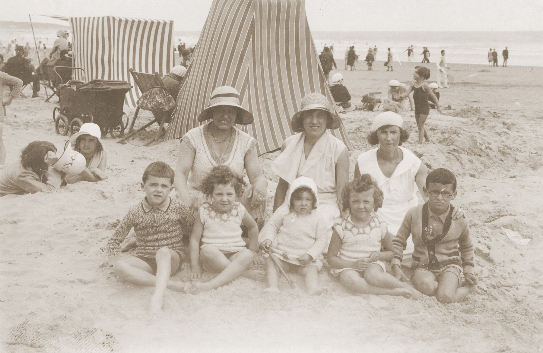 The Rubinsztejn family poses in front of a cabana on a beach in France. 

Pictured are Denise Grynberg, Eveline Grynberg, Dworja Rubinsztejn, Armand Rubinsztejn, and Chaya Grynberg Rubinsztejn.