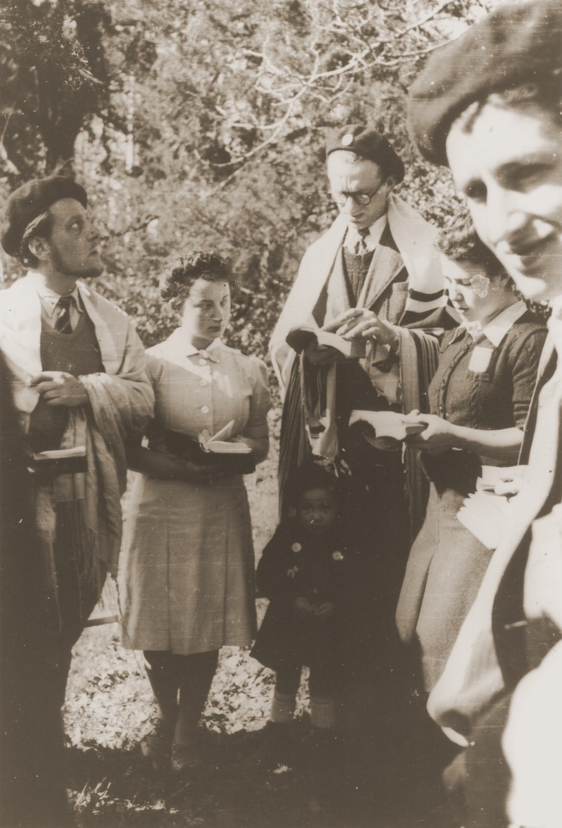 Leo Cohn, a Jewish refugee from Germany who directed the youth center in Strasbourg, leads religious services at an encampment of the Eclaireurs Israelites de France [Jewish Scouts of France].  

Leo Cohen was killed during the war.