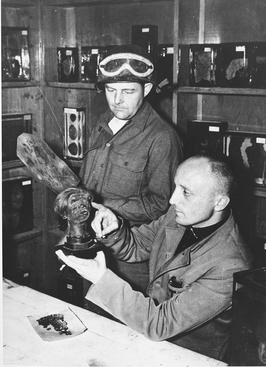 A Czech scientist and Wendell Birmingham, an American soldier, examining a shrunken head in Buchenwald after liberation.

The Czech was a former prisoner who was forced to dissect cadavers in Buchenwald.  The head is of an executed Pole, which, on the instructions of the SS, had been shrunken according to the method used by the Jivaro Indians of Ecuador.  Visible behind them are pieces of tanned, tattooed human skin and organs, all stored in the pathology laboratory where the SS forced staff workers to dissect the bodies of dead prisoners and make a collection of abnormalities.