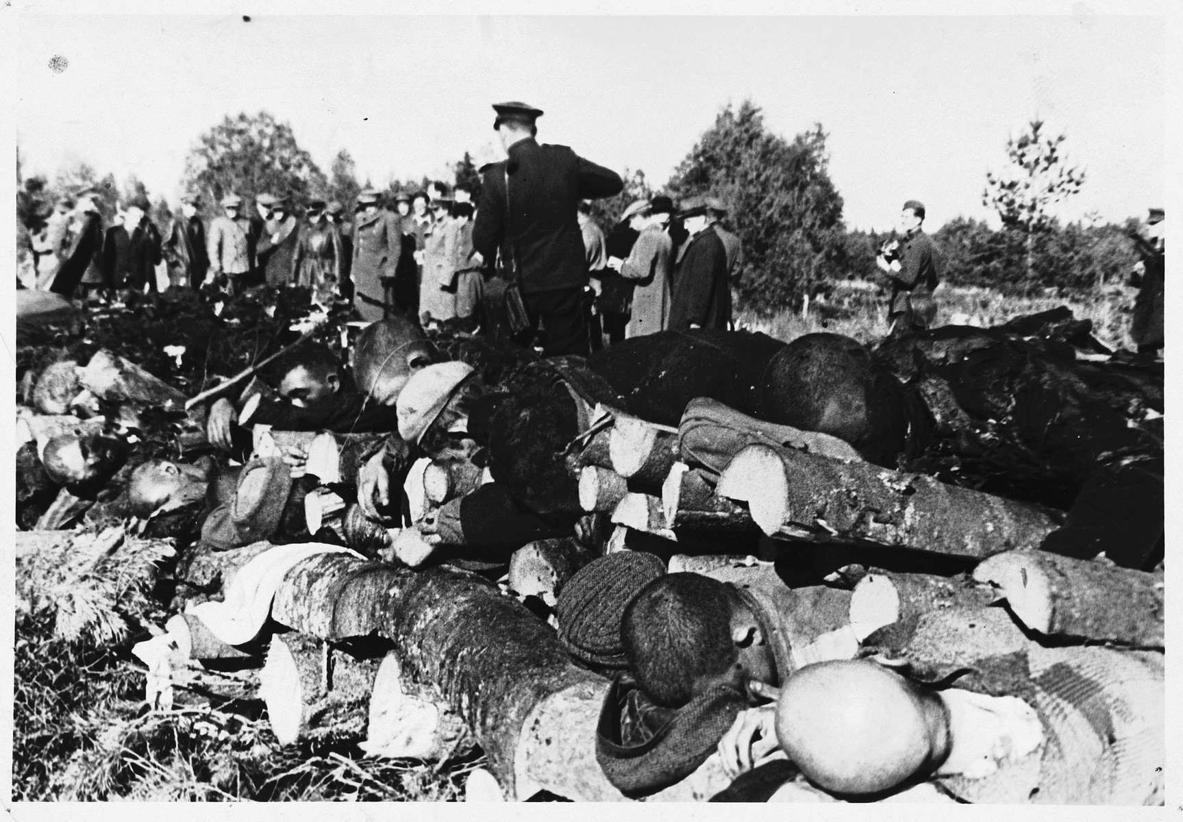 Soviet war crimes investigators view the corpses of prisoners in the Klooga concentration camp that have been stacked on a pyre for burning.