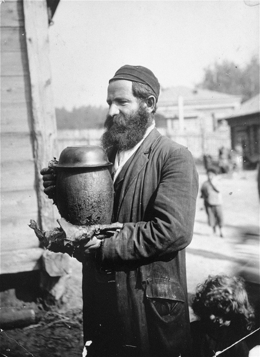A Jew carries a pot of cholent [stew] to be cooked for the Sabbath.