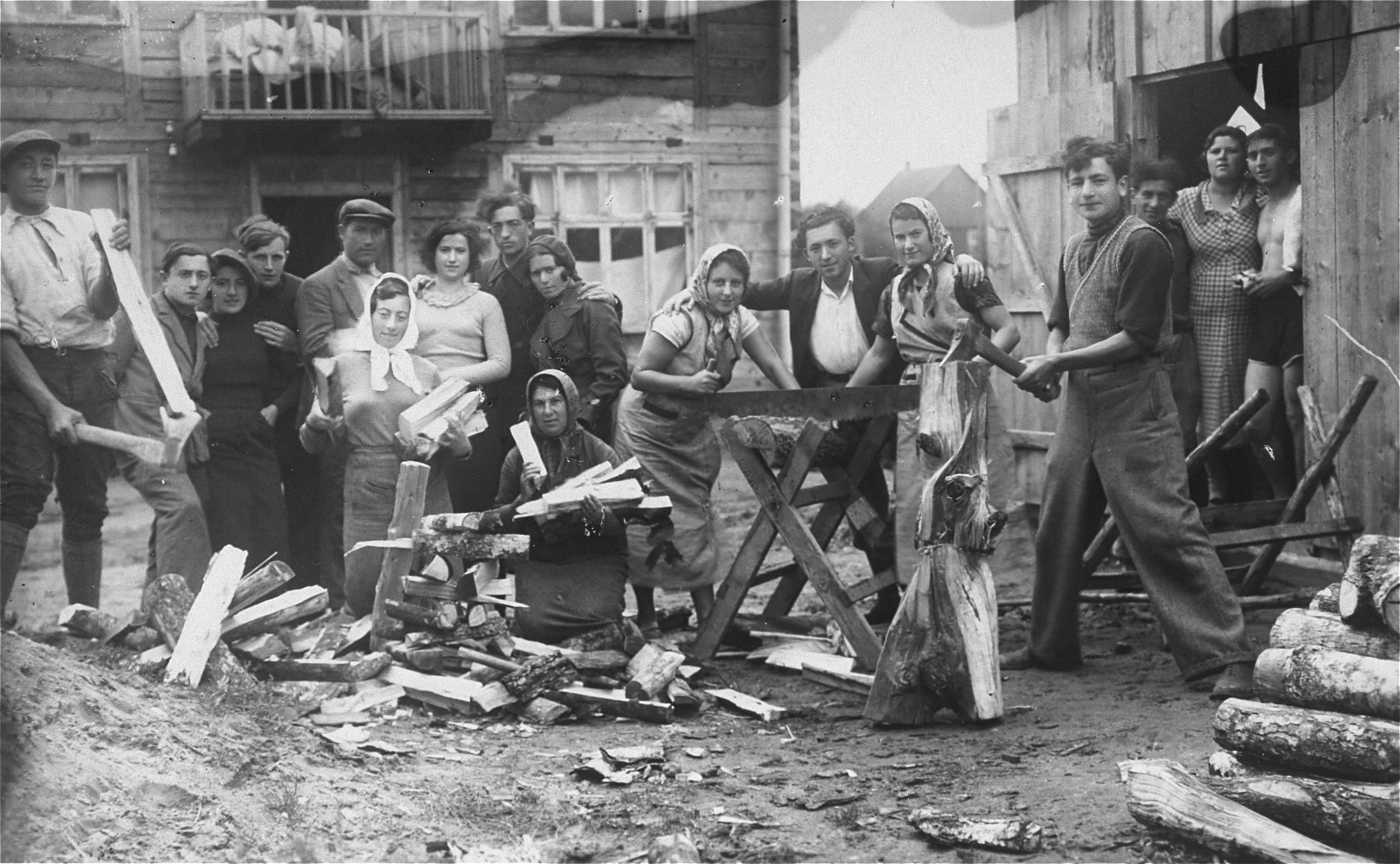 Members of a hachshara (Zionist collective) chop wood for fuel.

Eliezer Kaplan is pictured with his arms around two women.