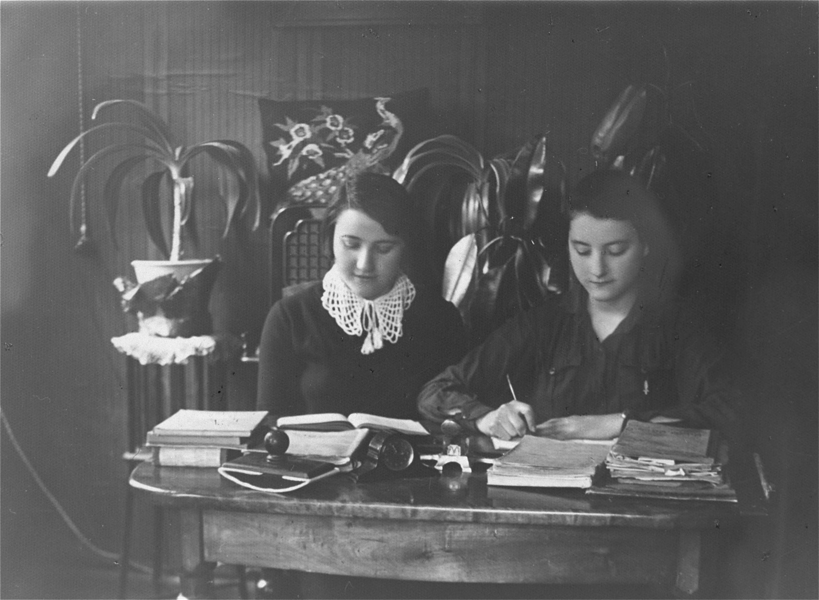 Two young women, who were members of the kibbutz hachshara Hakovesh, work as secretaries in an office.  

They inscribe the photograph to their friend Eliezer Kaplan: "In memory of the days that we spent together in kibbutz Hakovesh in Taurage..."