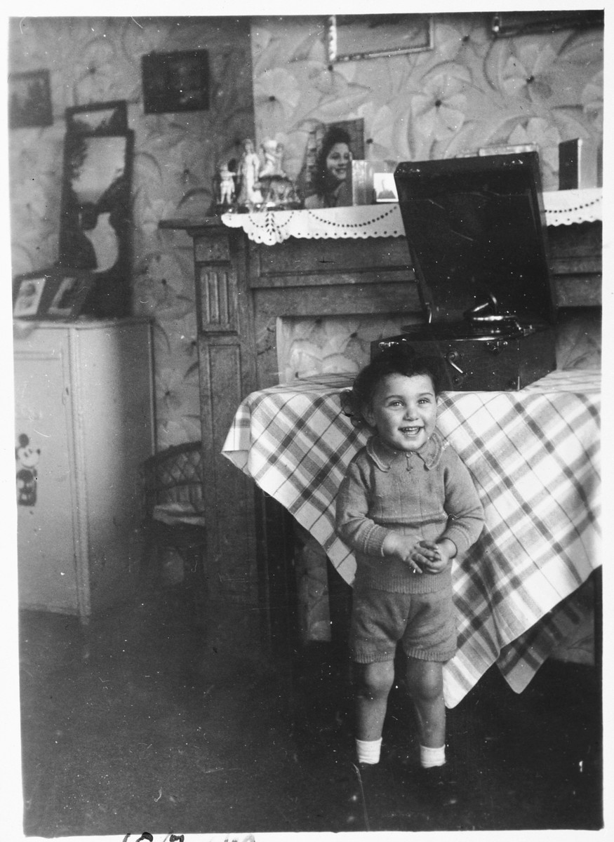 A young Jewish boy listens to the music of a phonograph while living in hiding as a Christian in Brussels.

Pictured is Nathan (Nounou) Ciechanow.  He was subsequently deported to his death in Auschwitz.