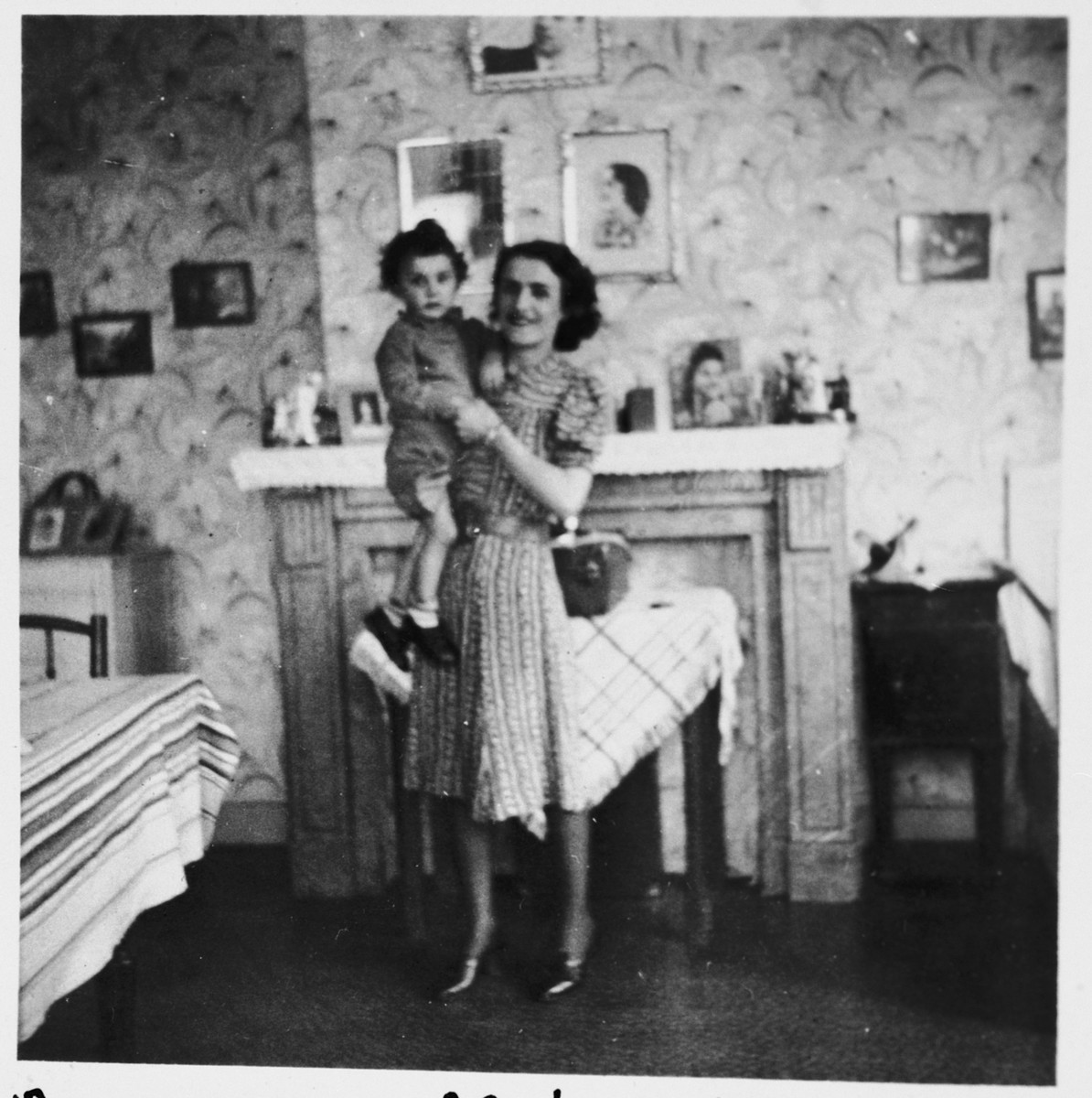A Jewish mother holds her young son in their apartment in Brussels, where they are living in hiding as Christians.

Pictured are Leah and Nathan (Nounou) Ciechanow.  They were subsequently deported to their death in Auschwitz.