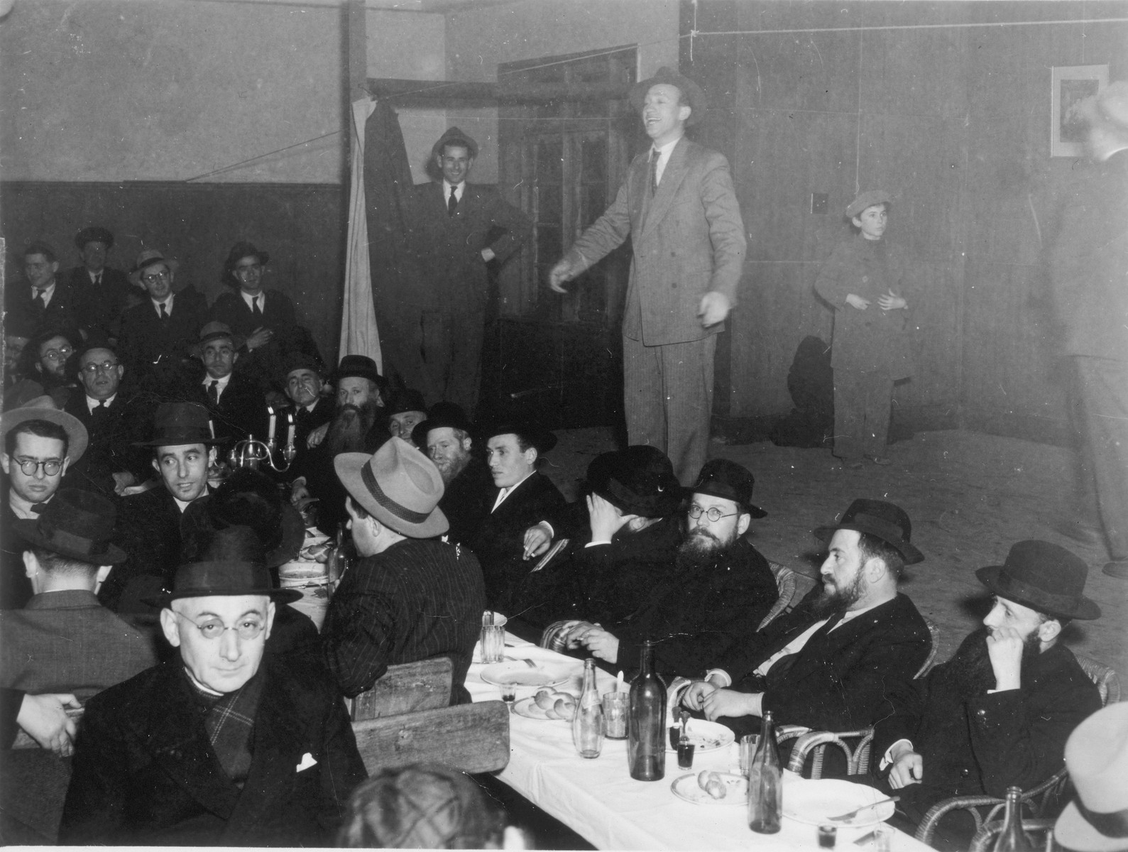 Yaakov Ederman entertains guests at a Jewish wedding in Shanghai.

Also pictured is Rabbi Shmuel Dovid Walkin, seated to the right of the candles, directly in front of the while curtain.