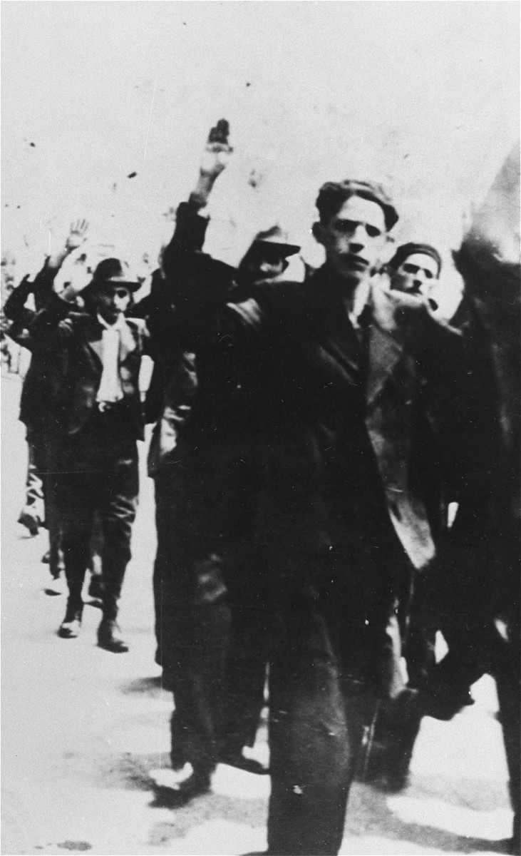 Jews arrested in Iasi are escorted to police headquarters with their hands in the air.