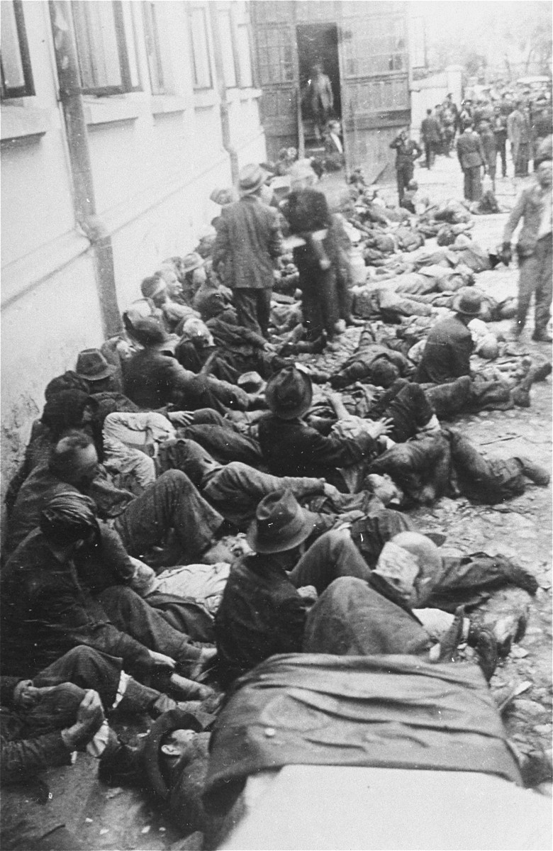 Jews assembled by Romanian police and soldiers during the Iasi pogrom sit among corpses in the courtyard of the city police headquarters.