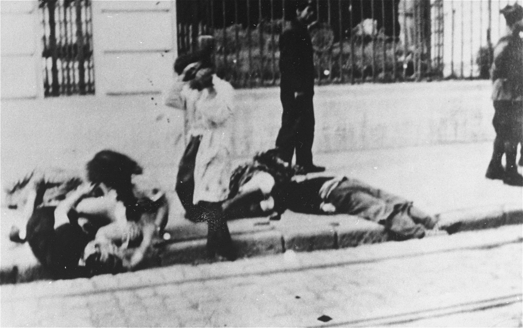 A man beats a Jewish woman on the street during the Iasi pogrom.