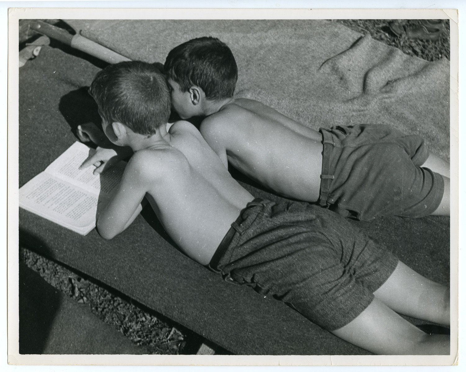 Two boys share a book in a displaced persons camp in Vienna.