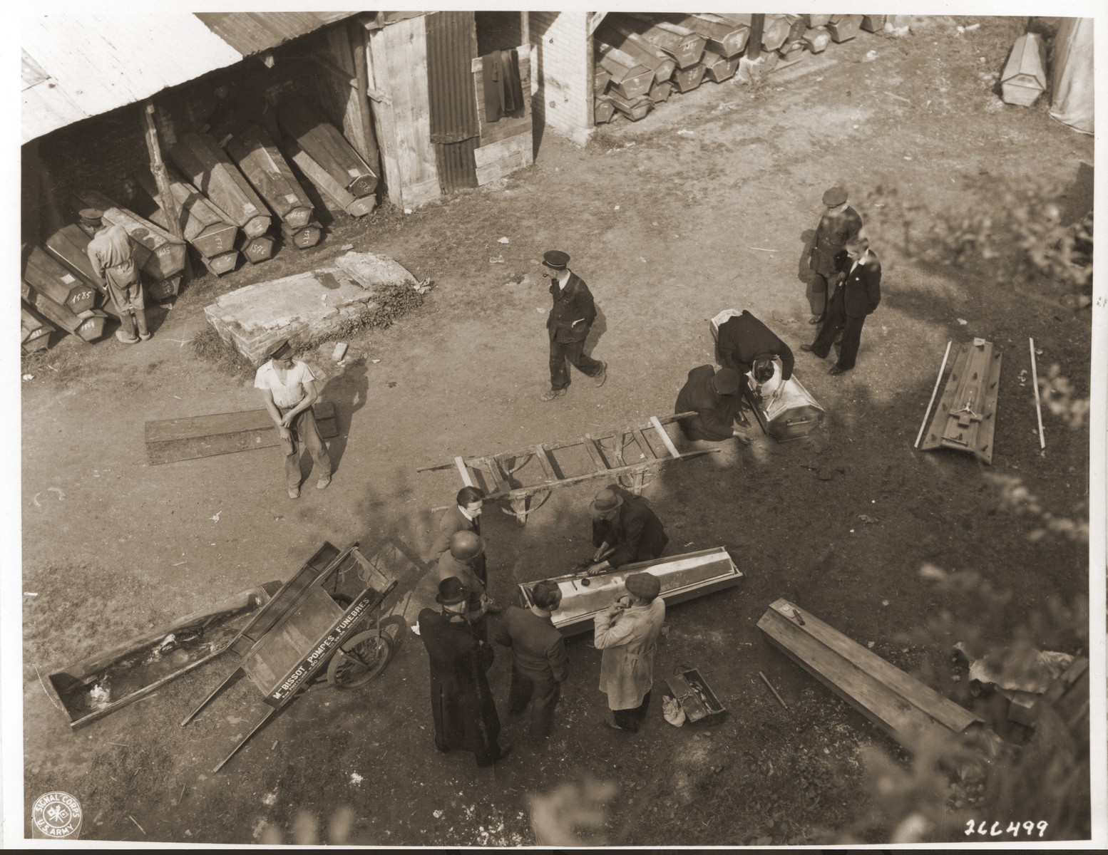 Belgian civilians place the bodies of Belgian political prisoners exhumed from a mass grave into coffins for reburial.