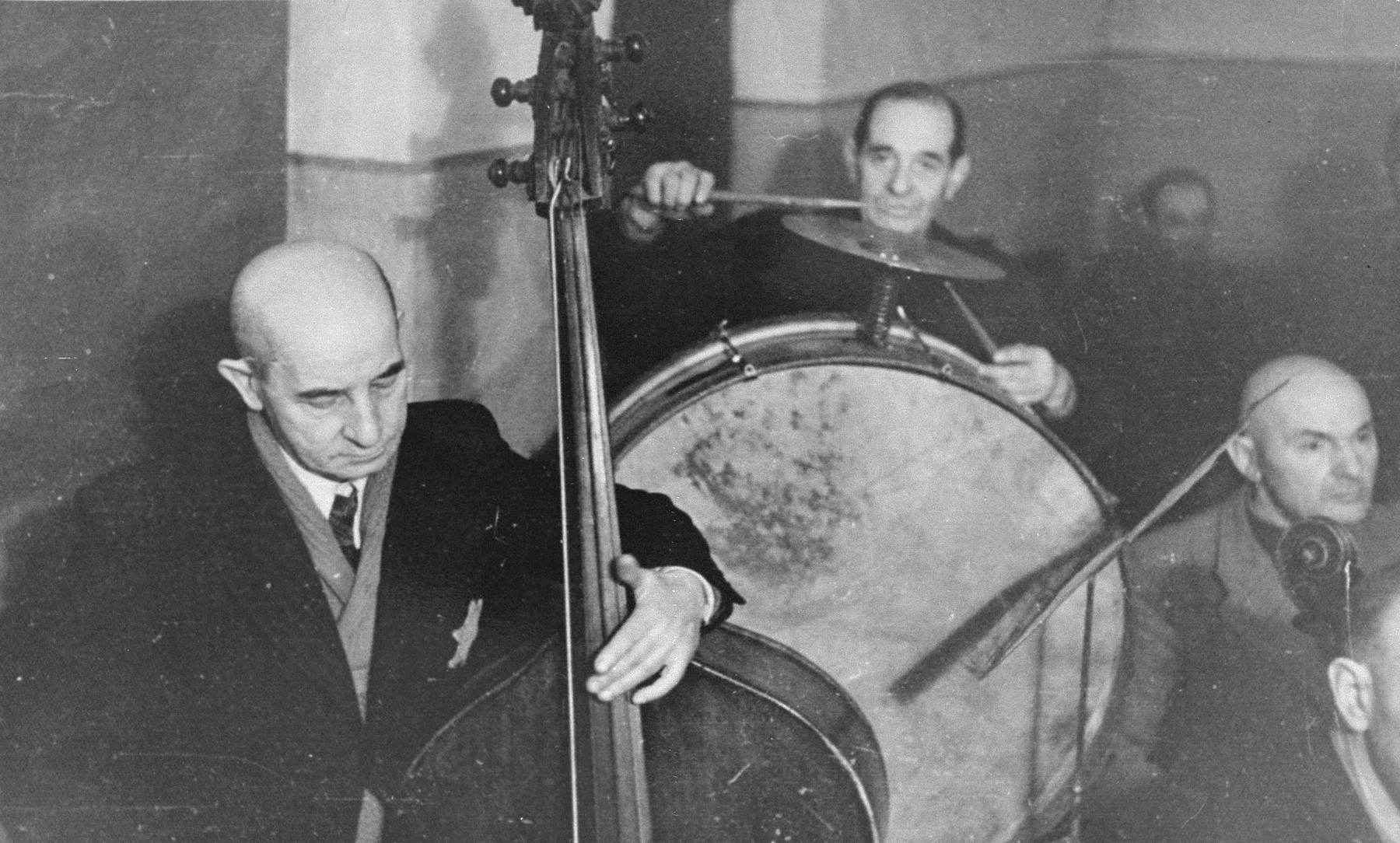 Performance of the Kovno ghetto orchestra. 

Among those pictured are: Yankele (the 13-year-old youth playing the violin at the back), Michael Hofmekler (standing at the left), Boris Stupel (sitting next to Hofmekler), Alexander (Shmaya) Stupel (standing at the top right).  Boris Stupel survived Dachau and later immigrated to Australia.  His brother, Alexander, perished in Dachau.