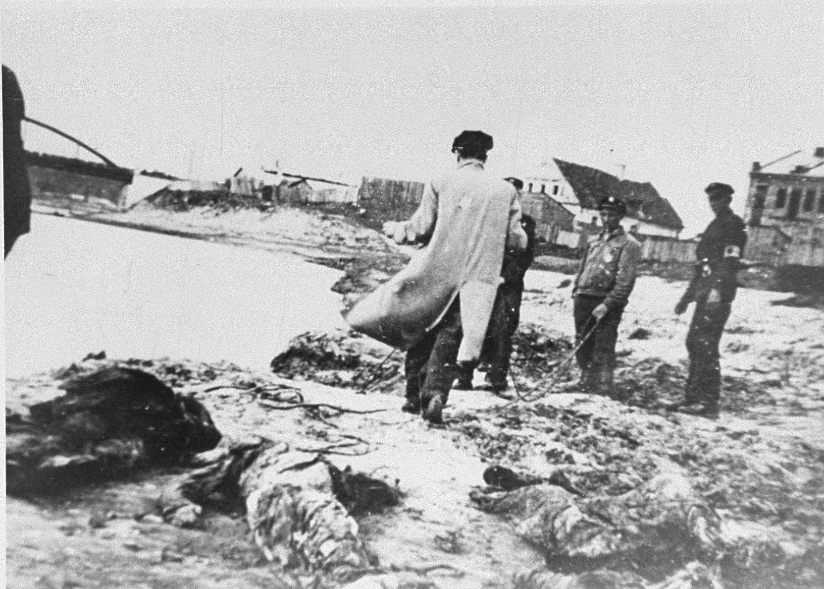 Members of the Kovno ghetto fire brigade pull the bodies of murdered Jews from the Viliya (Neris) River.
