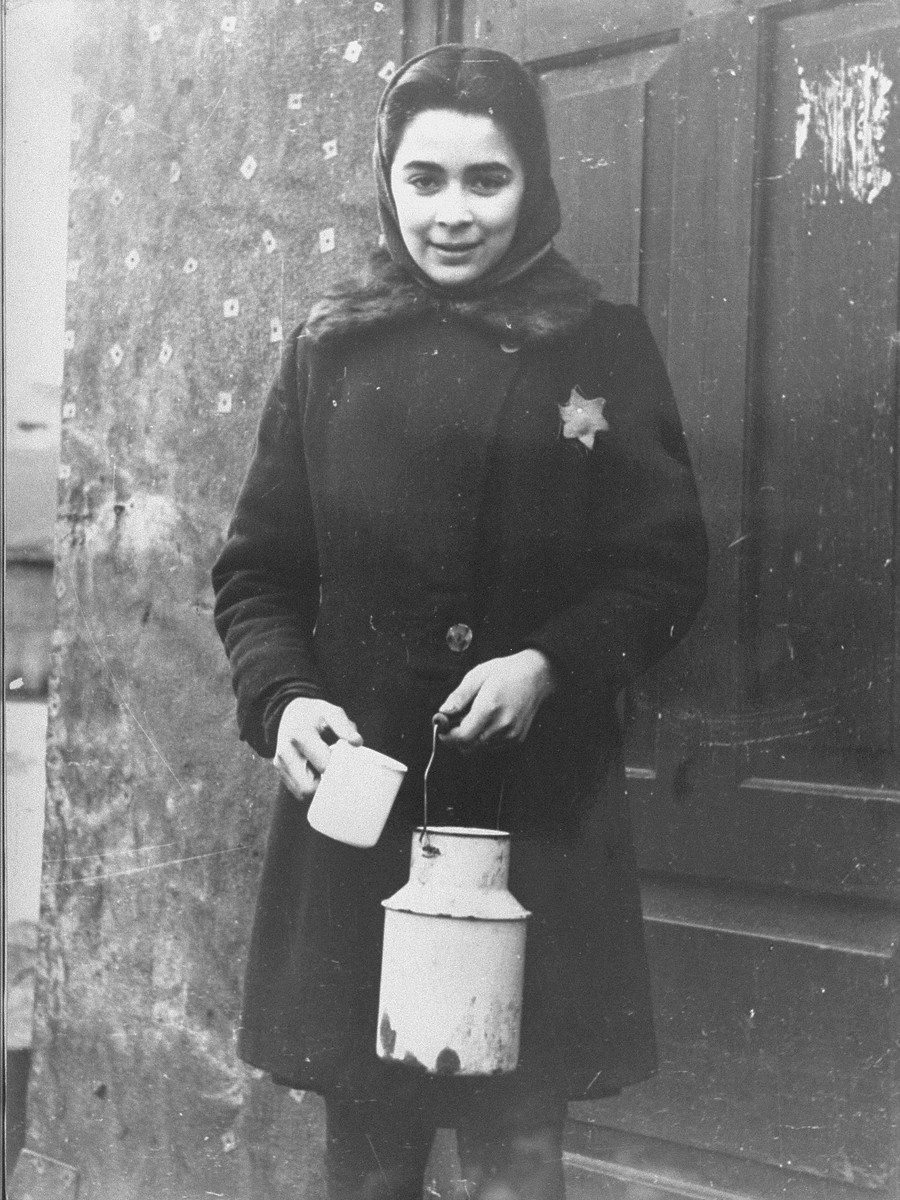 Portrait of a young girl holding a milk can in the Kovno ghetto. 

Pictured is Helen Verblunsky, who is delivering milk to one of her mother's customers, a gynecologist named Dr. Nabriskin.
