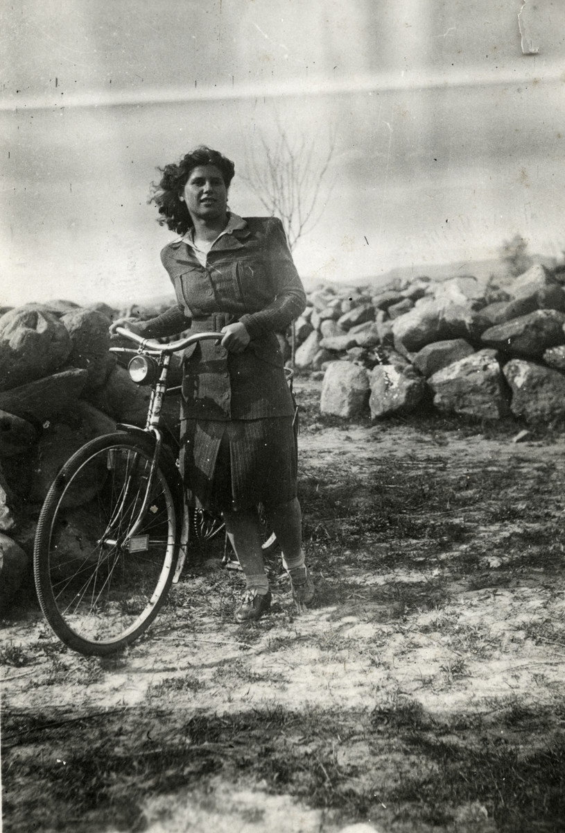 Esther Schaechter walks her bicycle through a field in wartime Hungary.