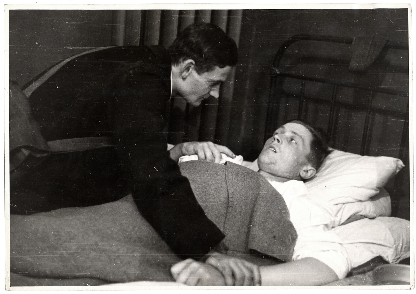 A Polish priest visits a sick/wounded German POW.