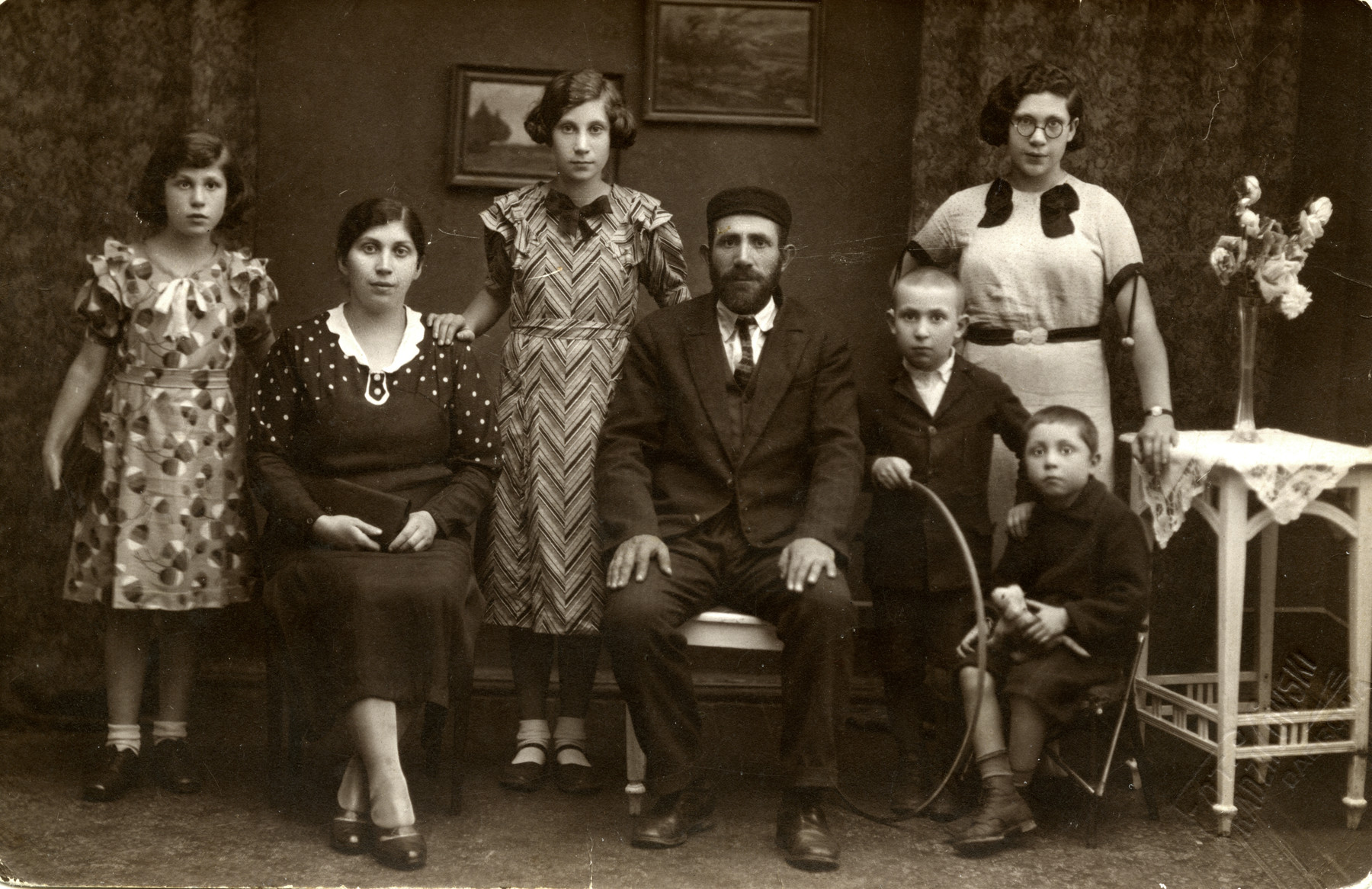 Studio portrait of the Welner family from Dabrowa Gornicza. 

From let to right; Ruzia Welner, Pesla, Rywka (donor's mother), Mordechai, Shimon, Shimshon, Hannah (standing behind). The photograph had been sent to Mordechai's brother, Getzel Welner, in America.