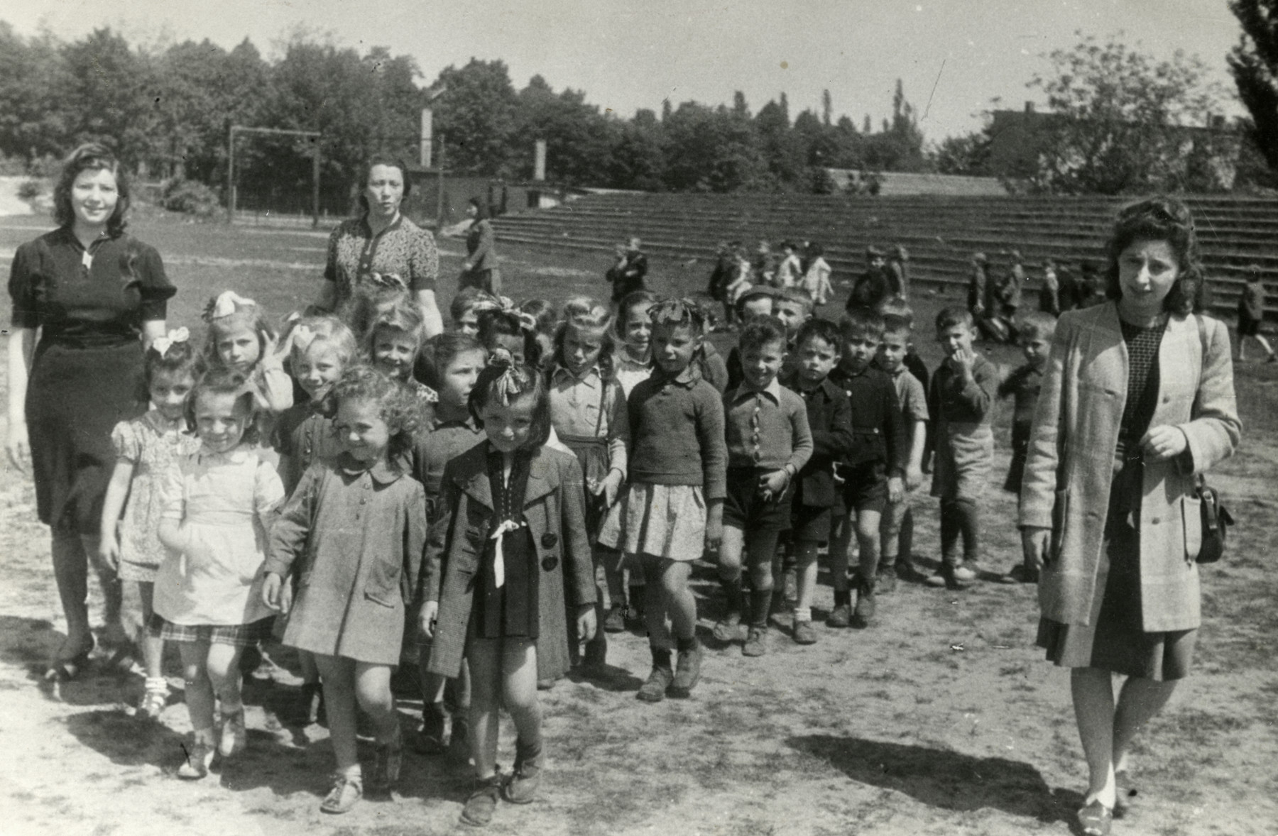 Group photograph of Bialik kindergarten class outing.  The location has been tentatively identified as the Mariendorf-Bialik Center, in the Volkspark Mariendorf. 

Eva Tabachnik is on right in front.